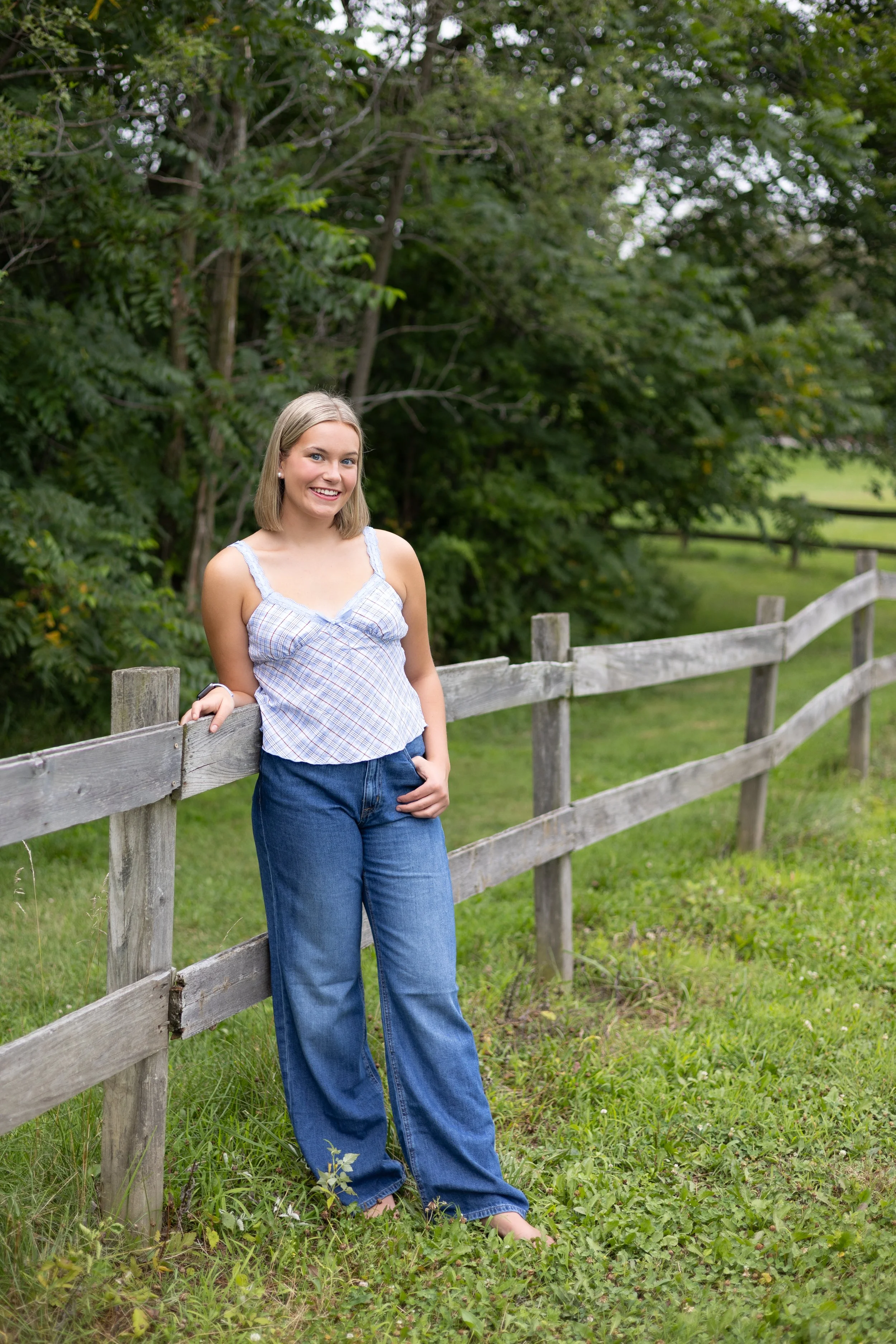 Senior leaning on a fence in a park in Huntington Indiana