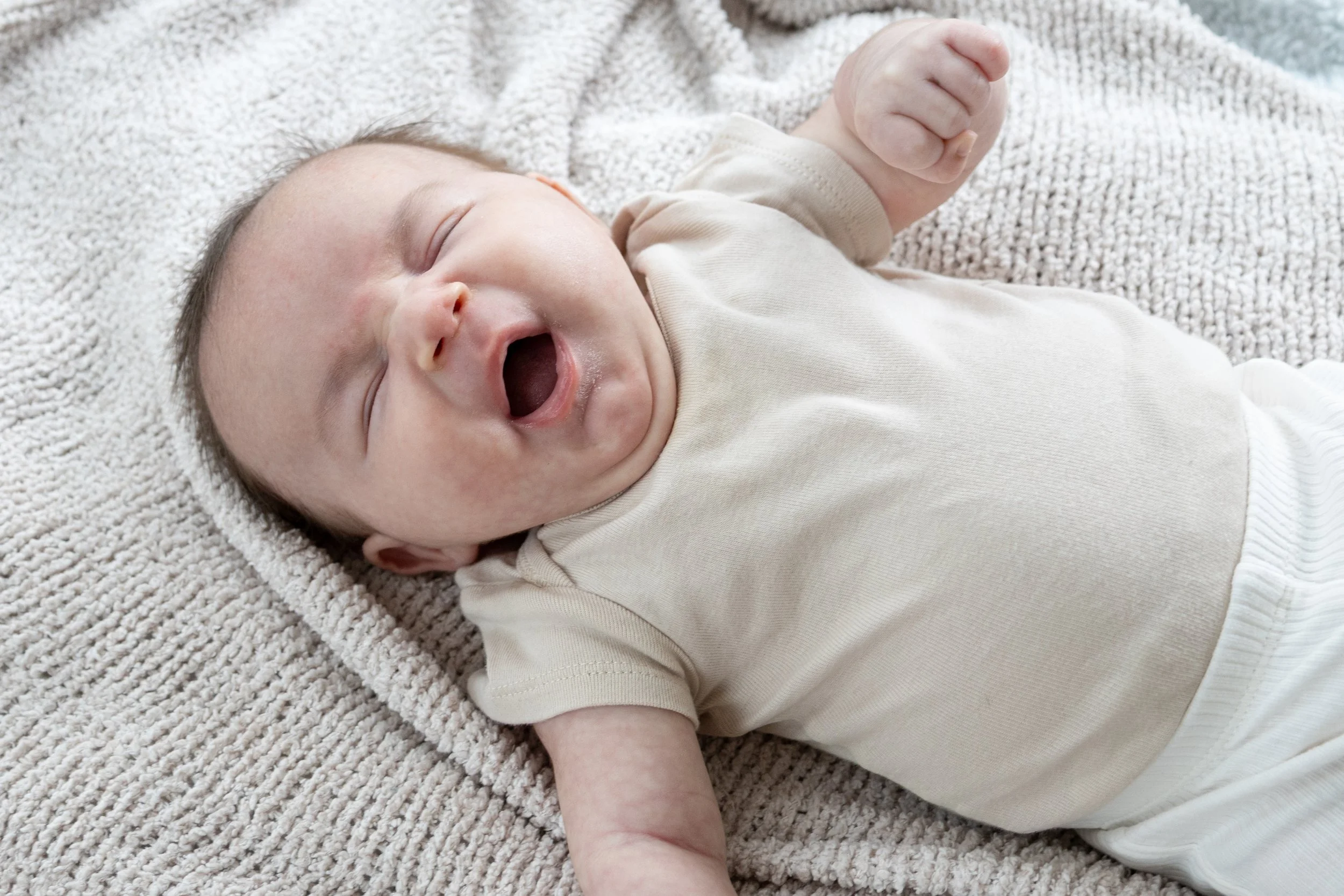 Baby yawning while laying on a blanket for a photographer in Huntington Indiana