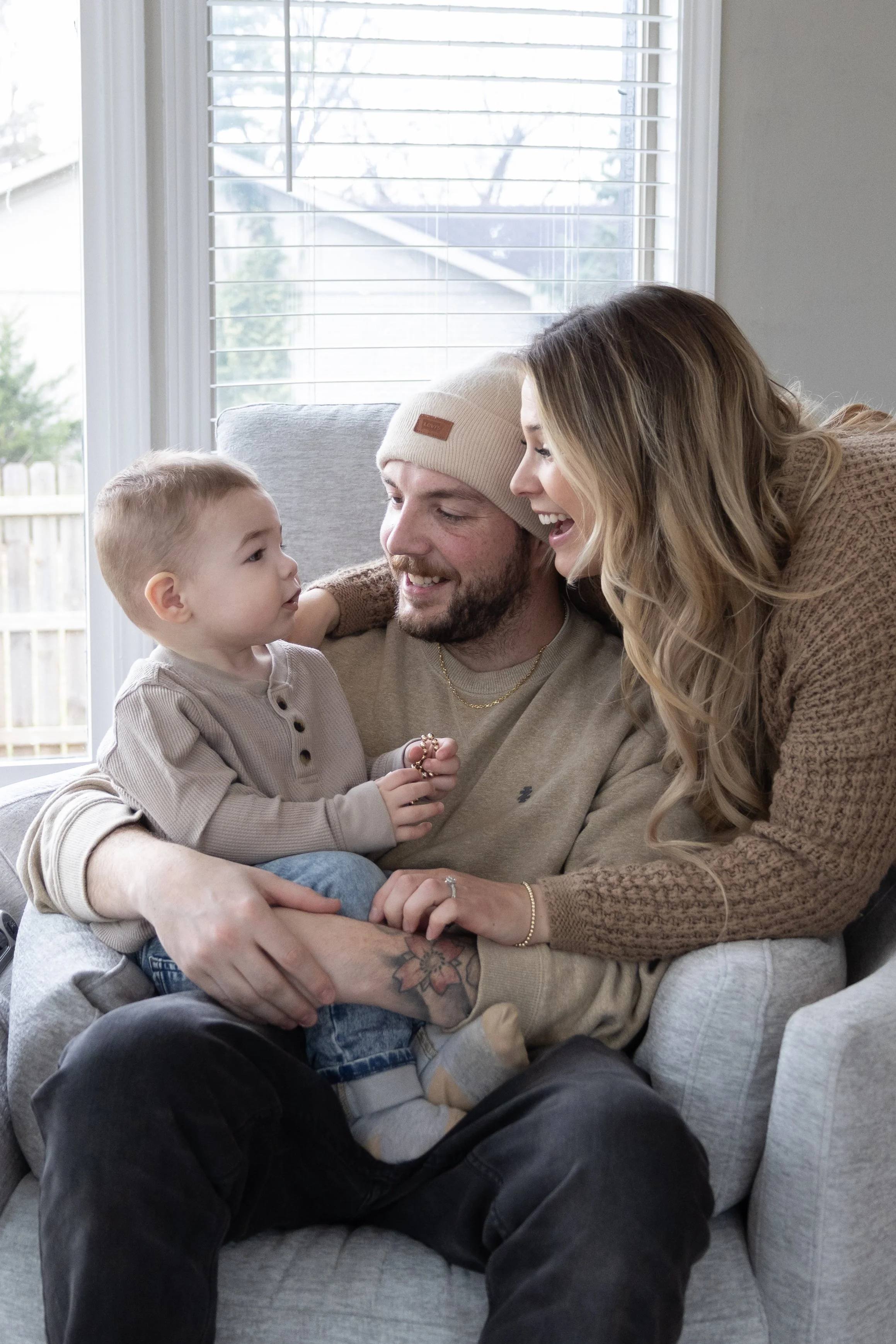 Mom and Dad adoring a baby and smiling in a home in Huntington