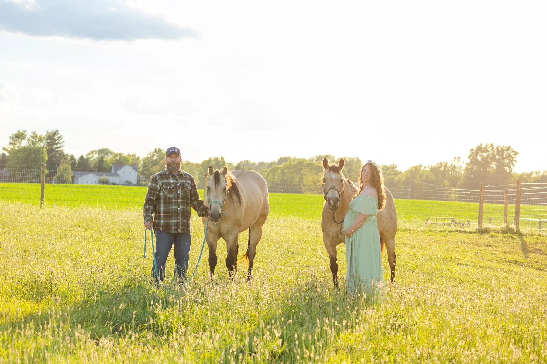 husband and wife with two horses in a North Manchester, Indiana farm field with the photograph taken at sunset
