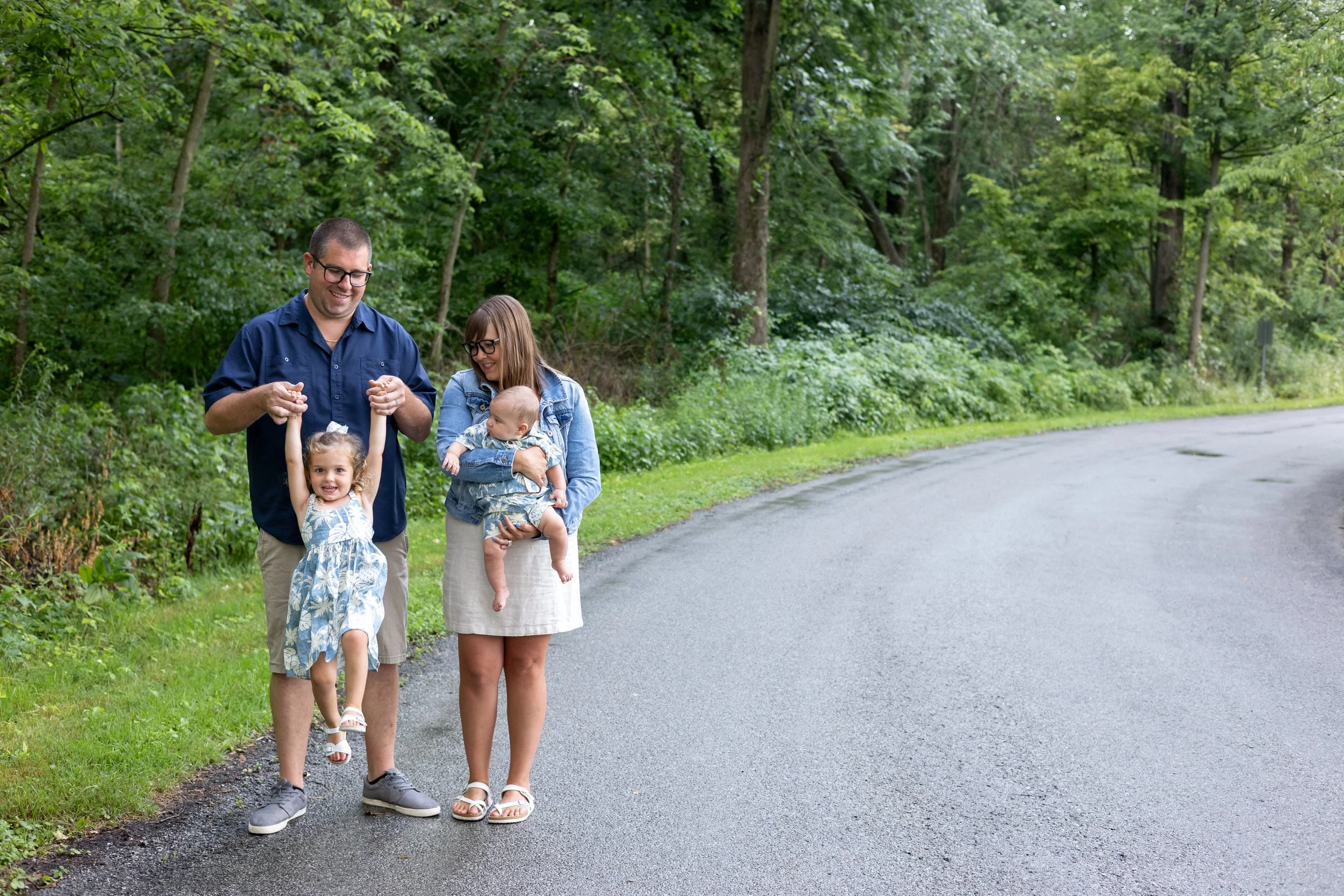 Family photo taken by a photographer in Huntington Indiana captures Mom holding a newborn and Dad playing with daughter