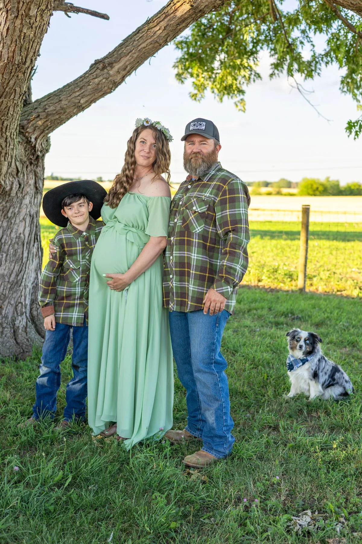 Family photographed standing under a tree with farmland in the background in North Manchester, Indiana