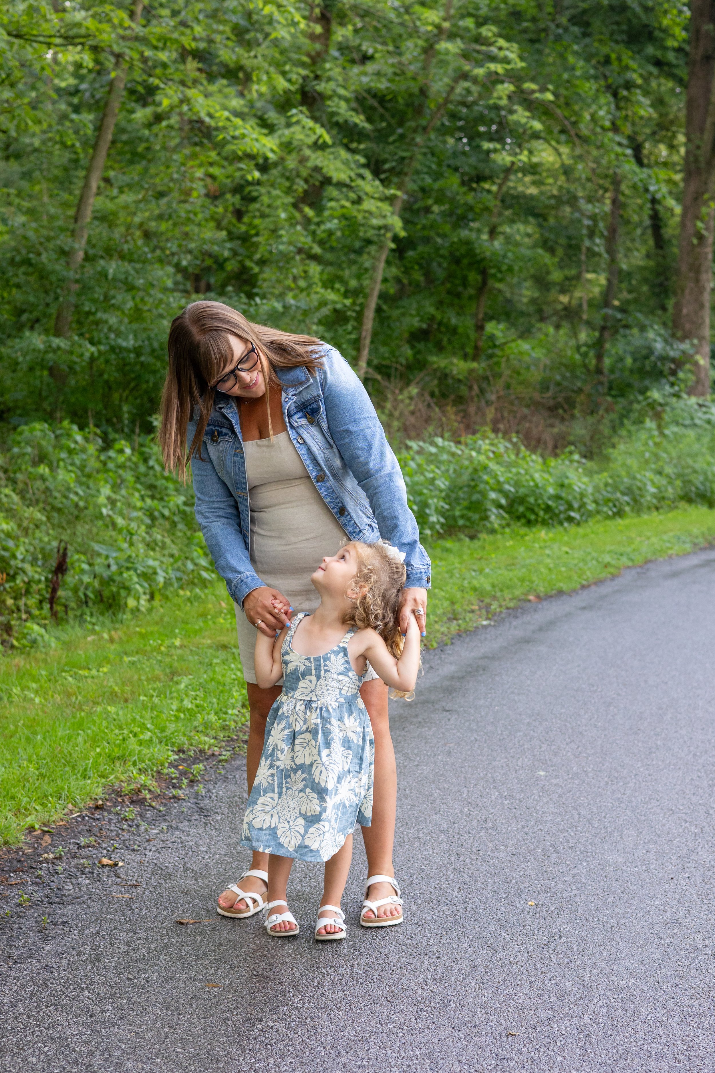 Mom and daughter photographer in a park in Huntington Indiana photographed with trees behind them just after a rainfall.