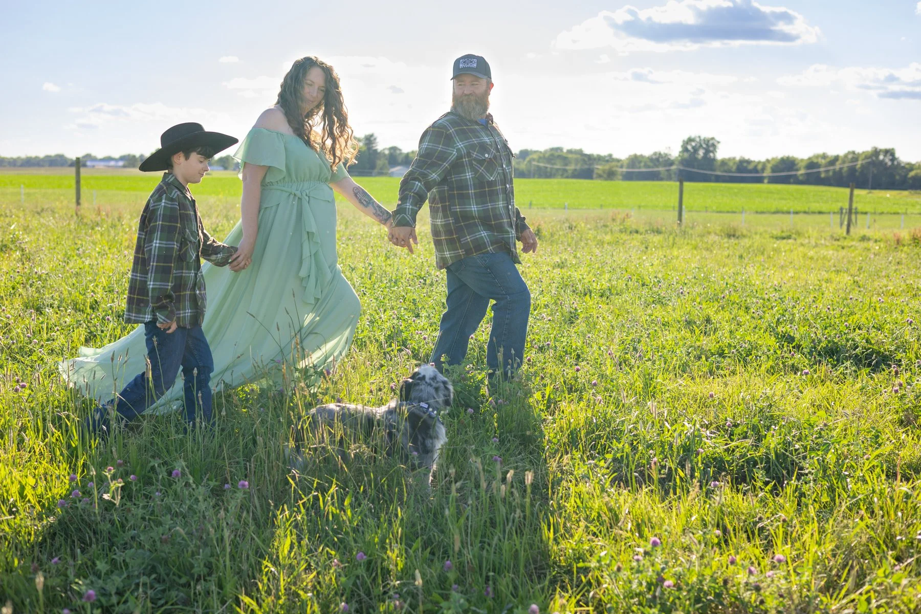 Family walking together in a farm field countryside setting with a dog in Indiana