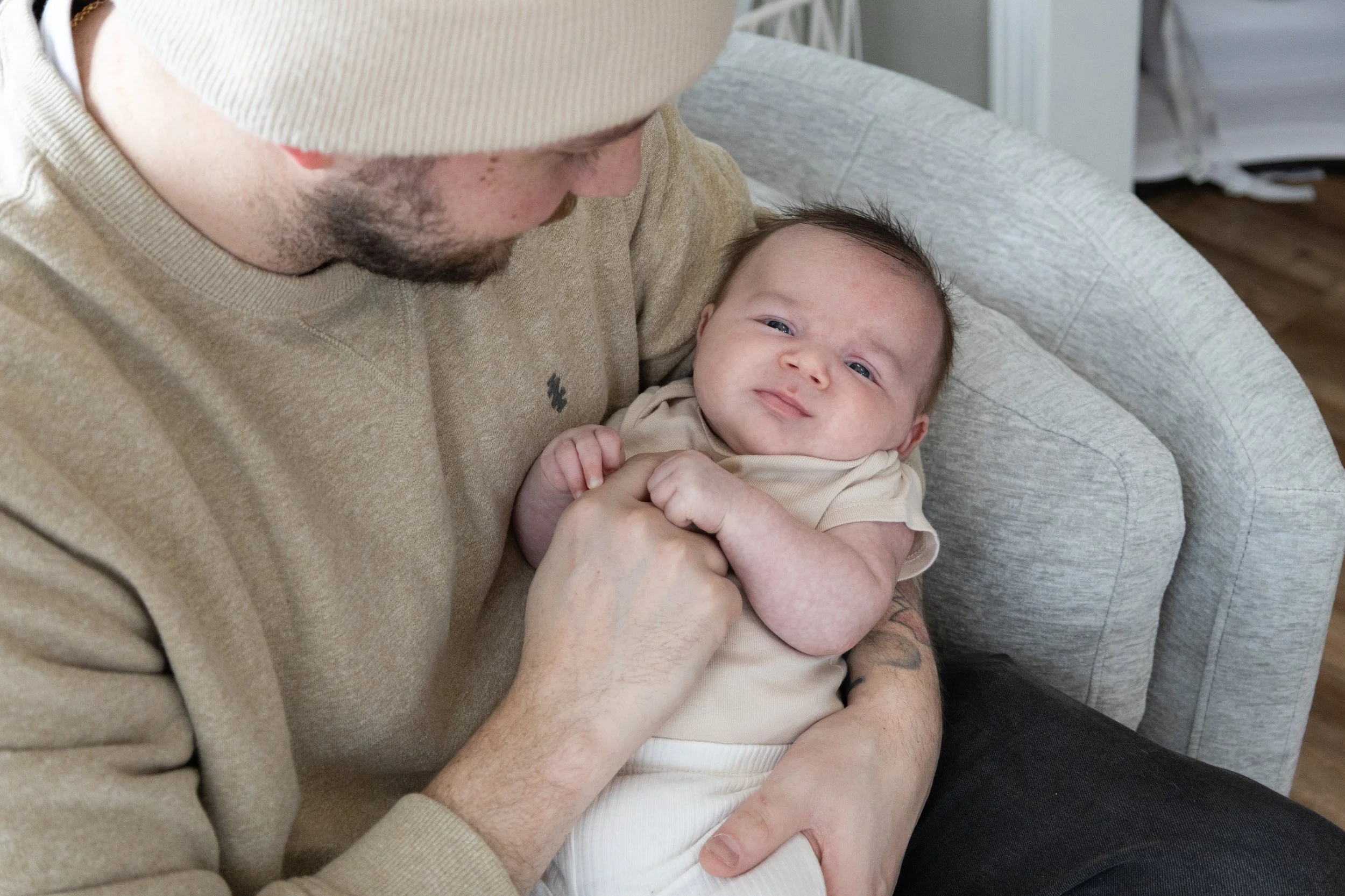 Newborn in dad's arms being held and loved photographed in a home in Huntington Indiana