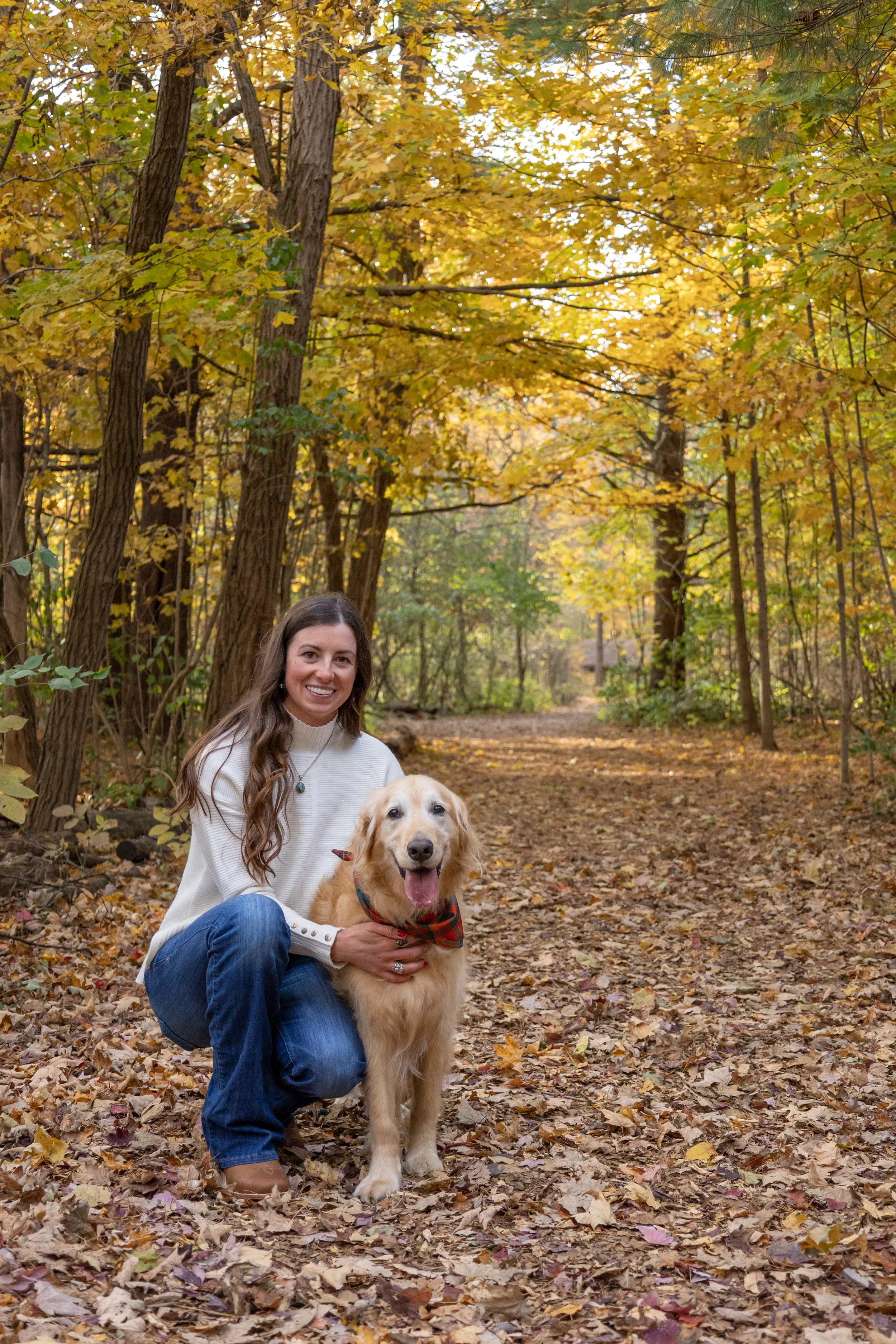 dog and mom photographed close together in the fall leaves and trees at homestead park in fort wayne