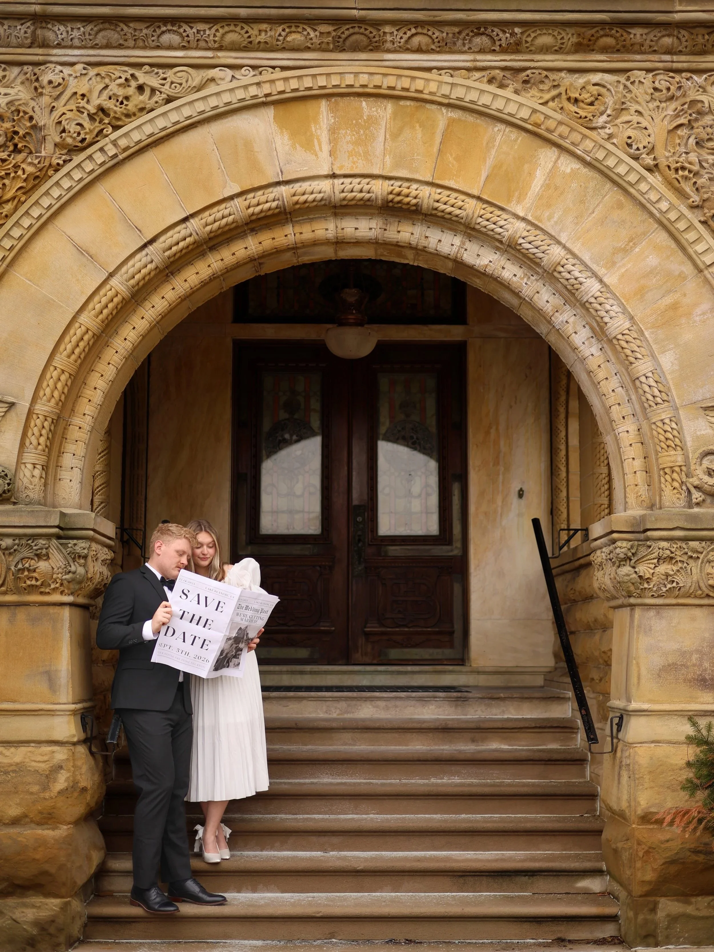 Engaged couple at St Francis in Fort Wayne Indiana reading a newspaper announcing their save the dates