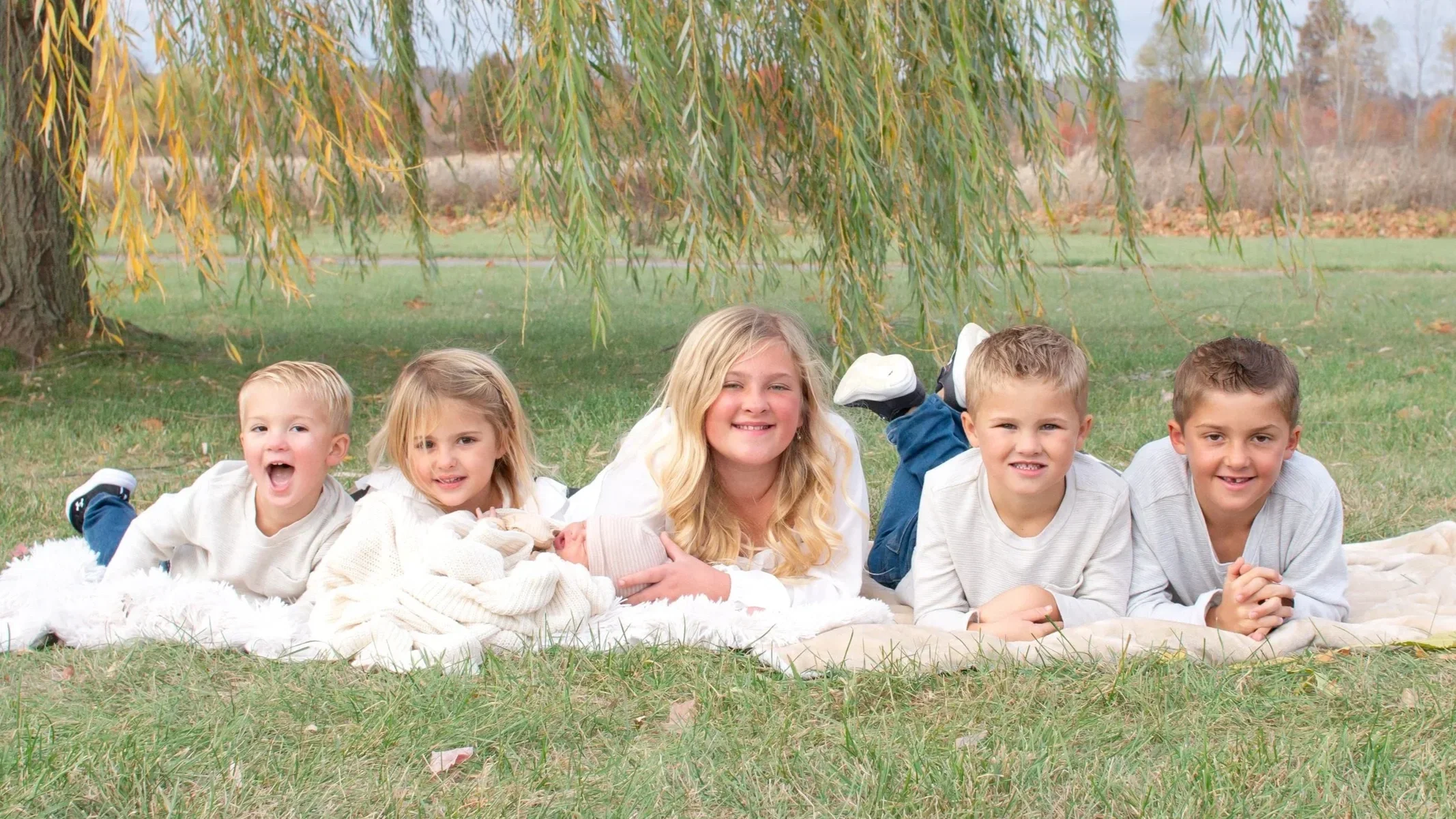 Siblings of a large family captured in a photo under a willow tree in Huntington Indiana