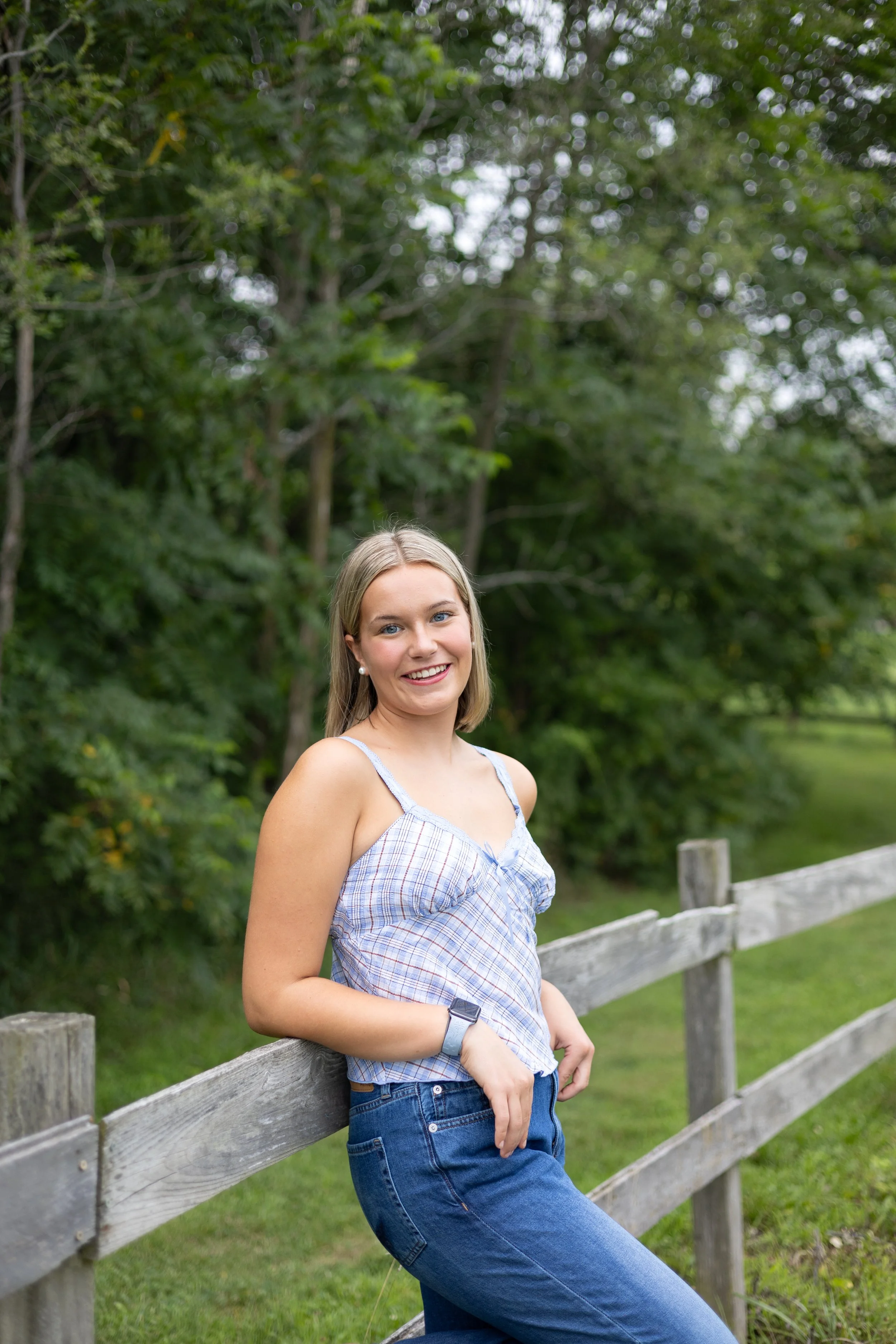 Senior leaning on a fence in a park in Huntington Indiana