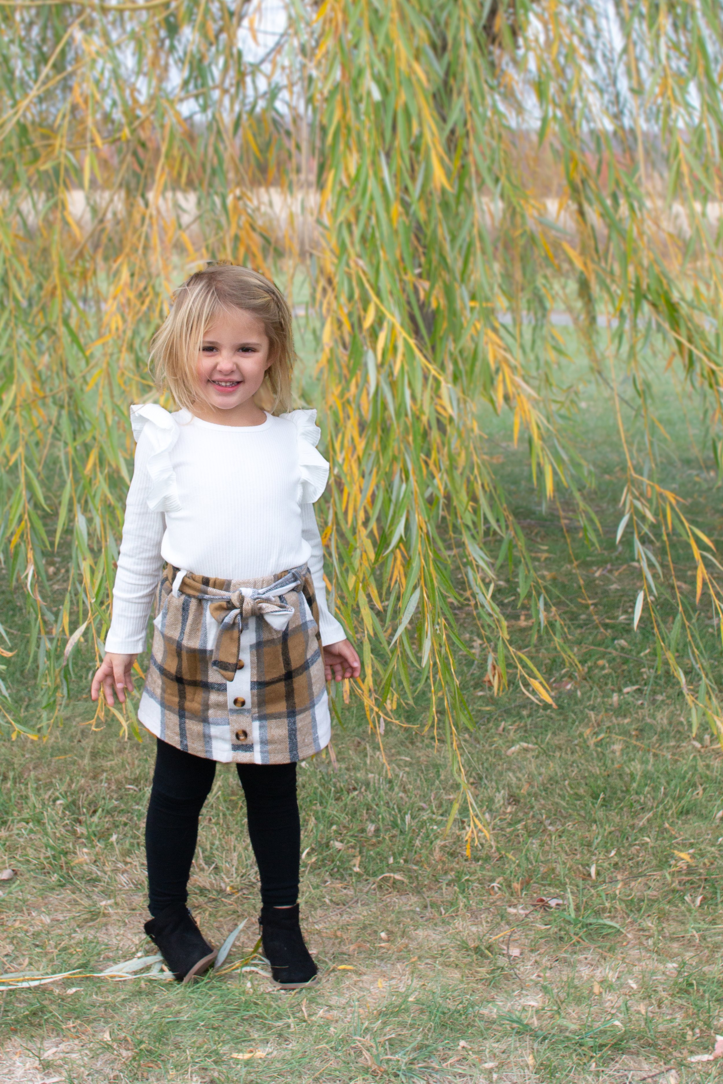 Girl standing and smiling by a willow tree in Huntington Indiana