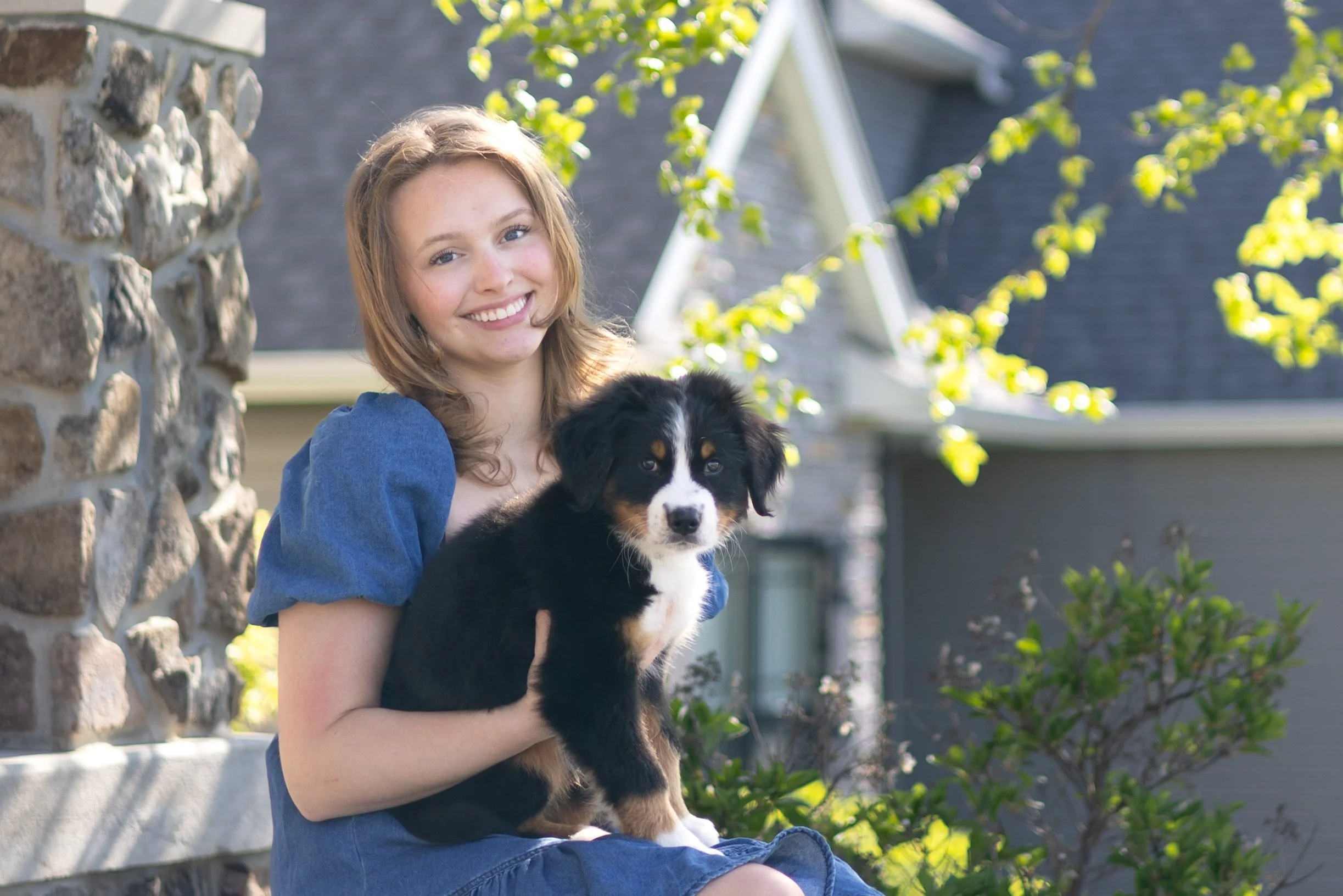 dog and mom photographed on the steps of home in fort wayne both are looking at the camera with candid smiles