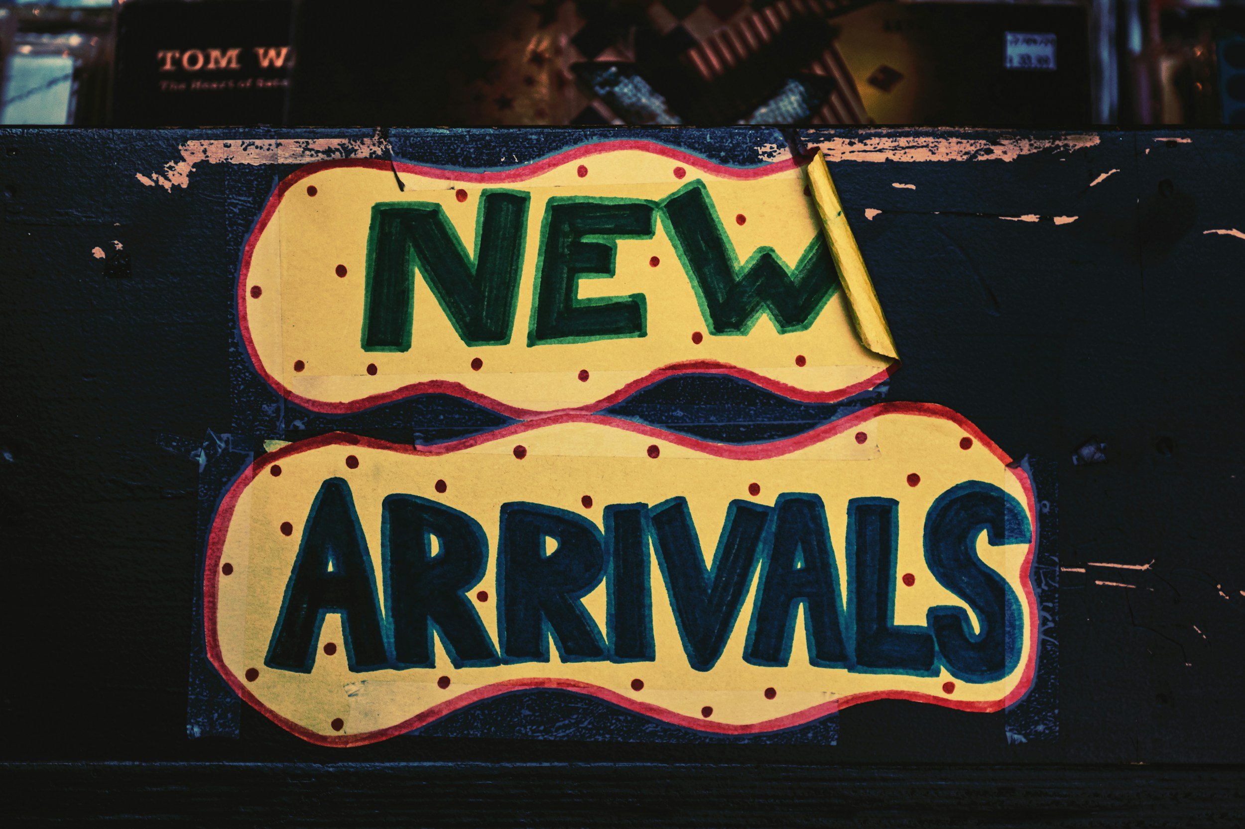 Colorful sign that says 'New Arrivals' with yellow background, red dots, and bold green and blue lettering. representative of small business services