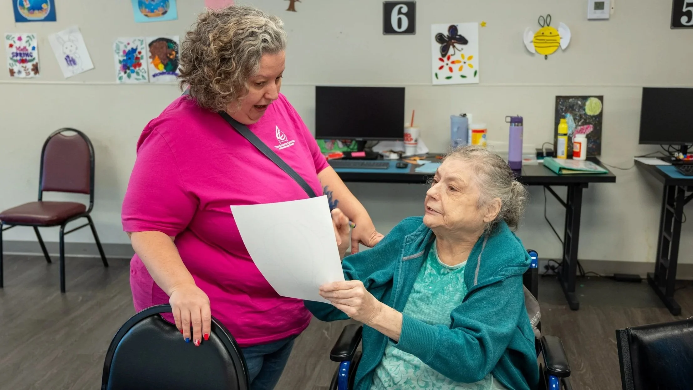 Adult services participant reviewing a budget worksheet with staff support at the Epilepsy Center of Northwest Ohio, practicing money management and financial independence skills.