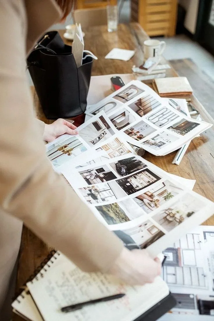 Designer d'intérieur à Laval comparant des planches d'ambiance et des plans d'aménagement sur une table de travail