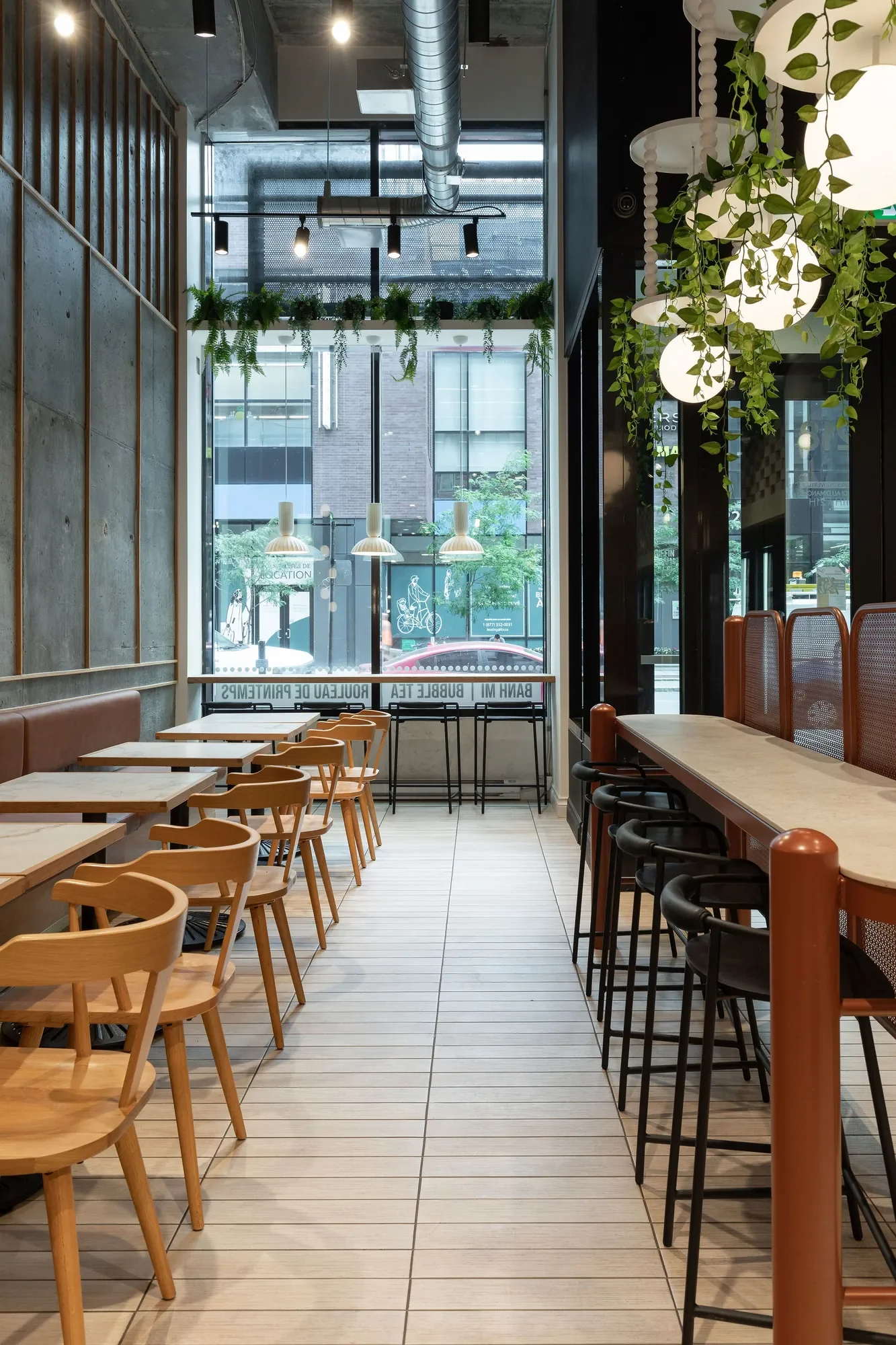 Aménagement du restaurant Sue Foods à Griffintown par Rübik Design : table haute, tabourets et globes suspendus