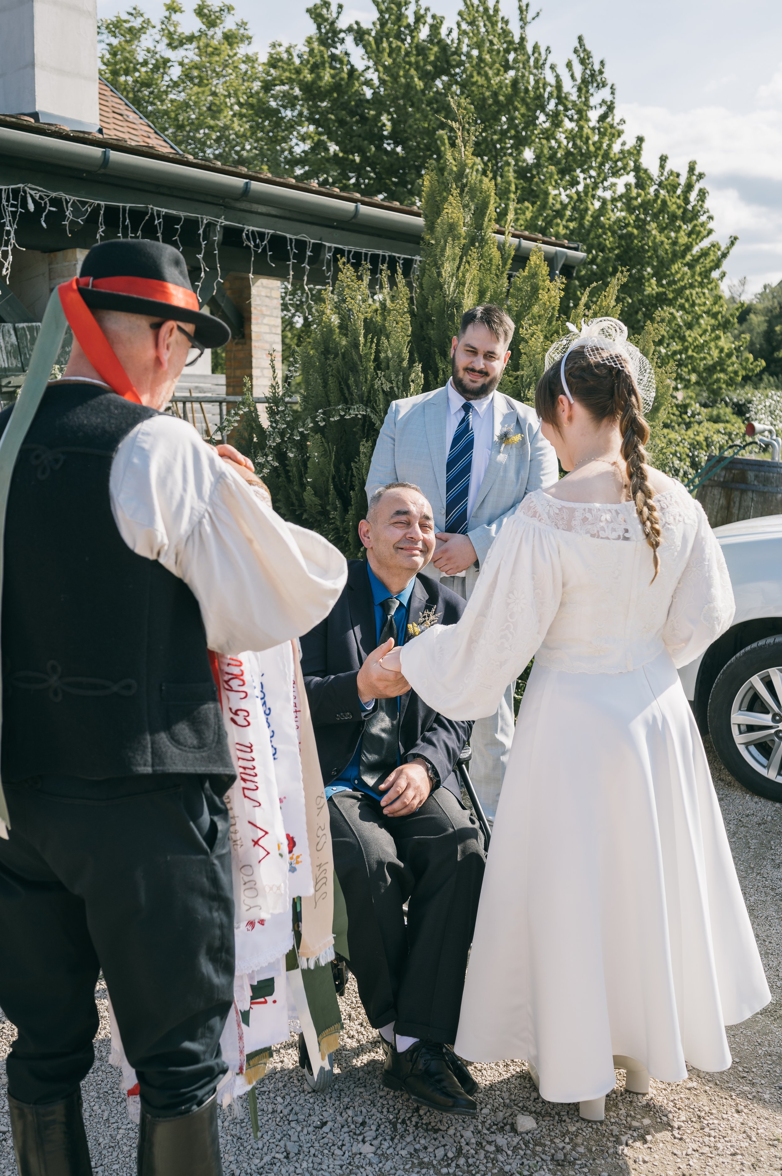 A woman in a white wedding dress looking at herself in the mirror, adjusting her earring.