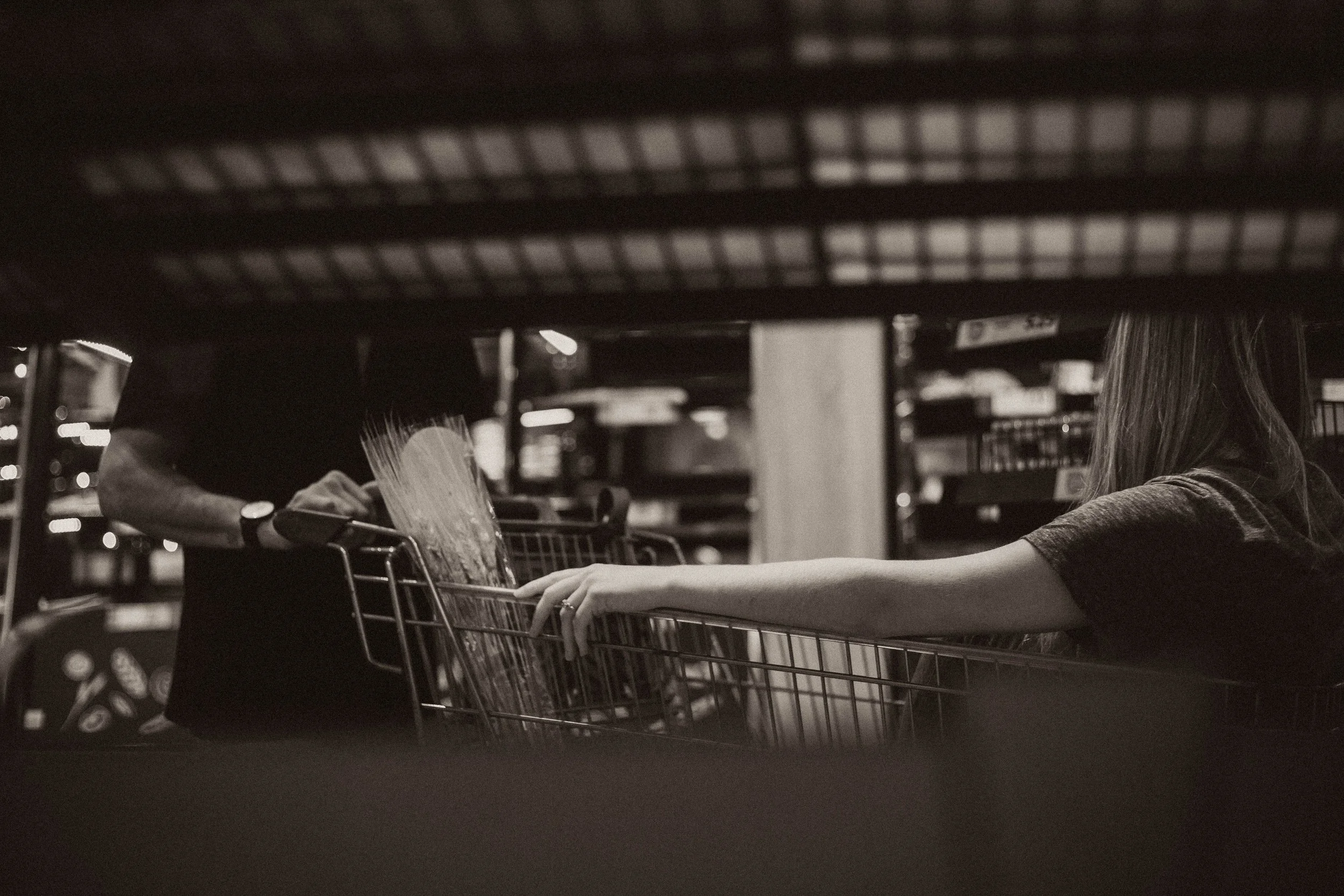 A newly engaged couple grocery shopping. In black and white.