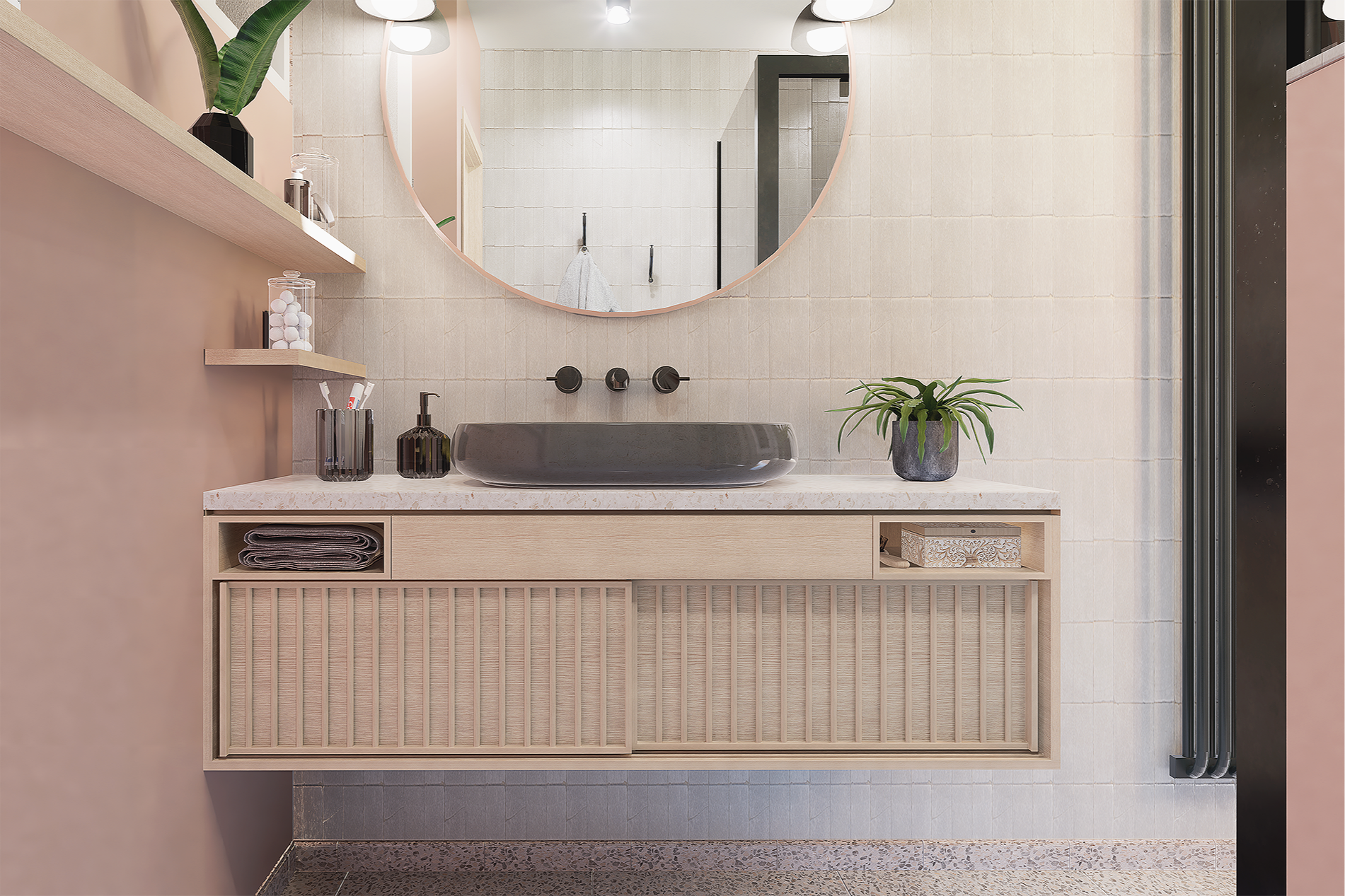 Meuble de salle de bain en bois clair avec un lavabo en pierre gris foncé, un grand miroir rond, des étagères avec quelques objets et une plante verte en pot sur le rebord.