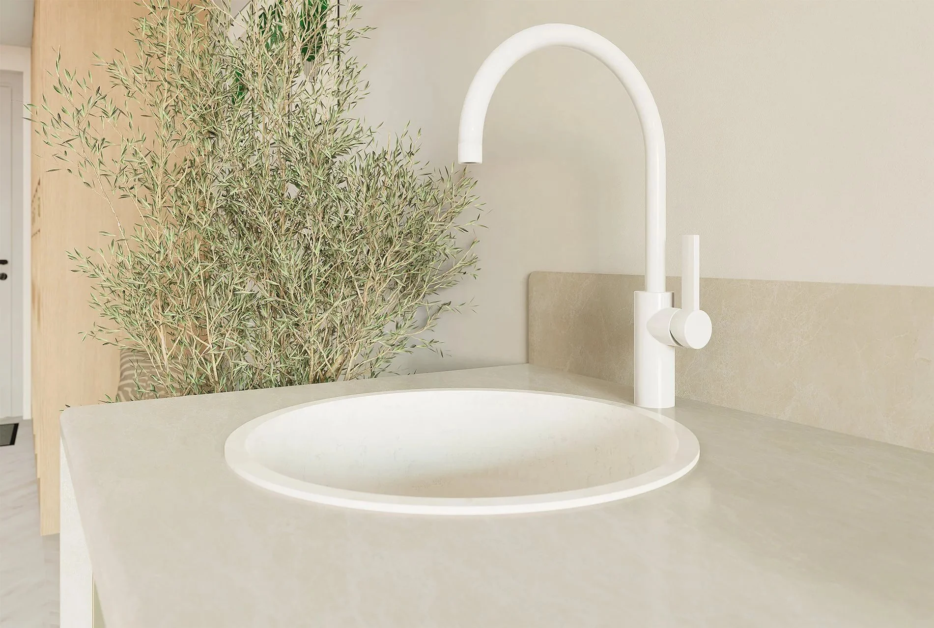 Vasque de cuisine en quartz blanc avec un robinet blanc et une plante verte en arrière-plan, mur beige clair.