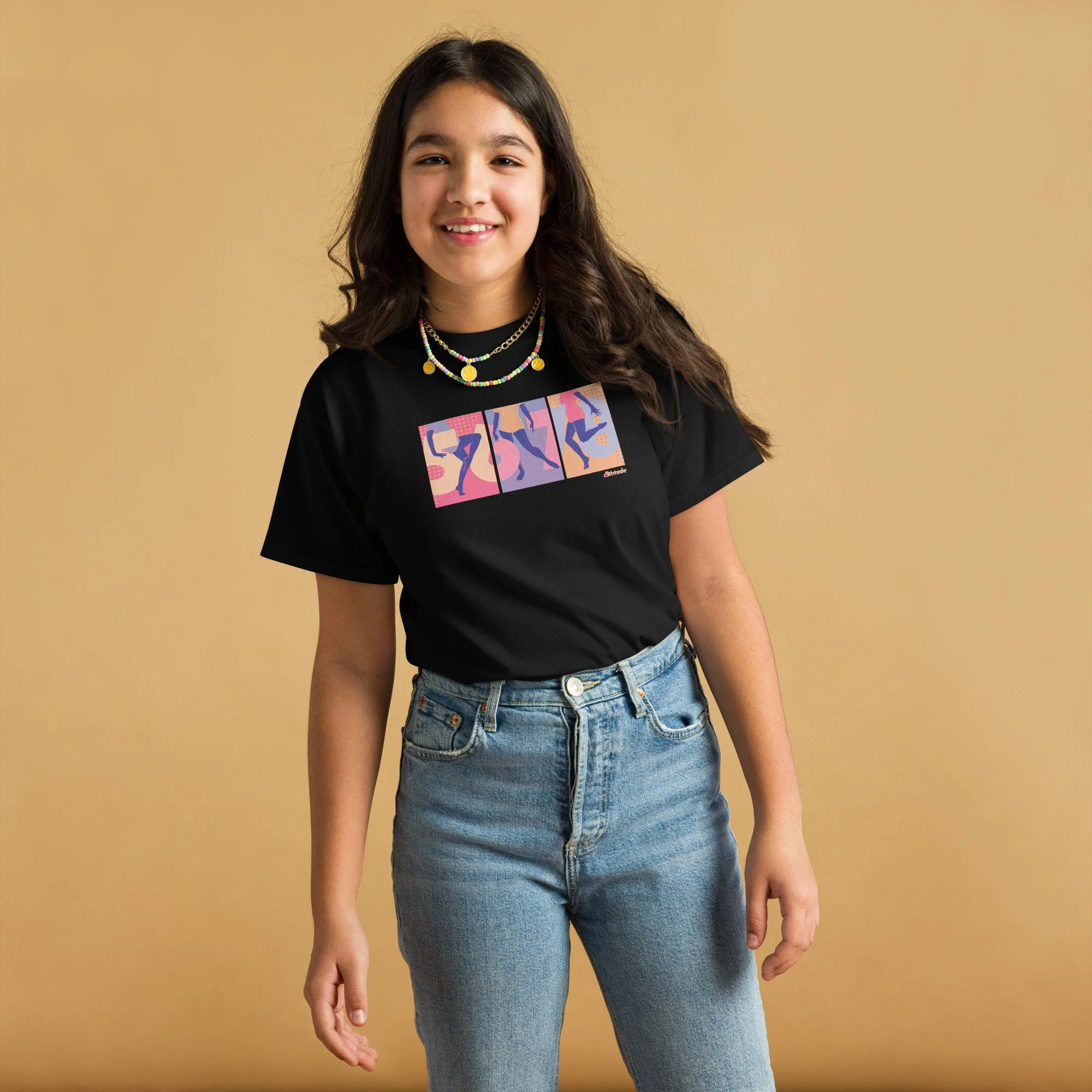 A teen girl with brown hair wearing a black graphic tee with 5,6,7,8 and three dancers' legs spanning 3 panels, blue jeans.