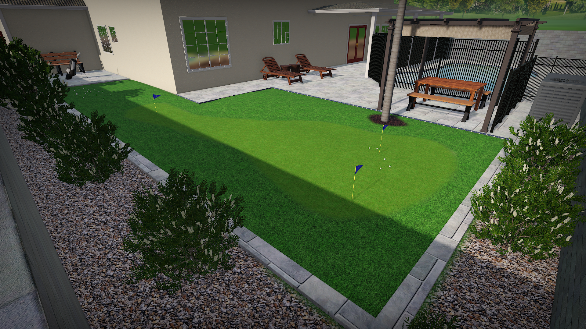 Backyard with a putting green, three flags, and golf balls, surrounded by a gravel walkway, shrubs, patio furniture, and a house with sliding glass doors.