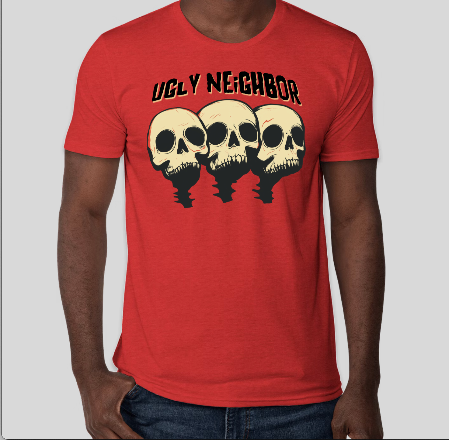 Red Ugly Neighbor band t-shirt featuring three cartoon skulls and horror-punk logo design. Soft cotton tee with bold graphic for fans of punk rock, alternative music, and retro horror aesthetics.