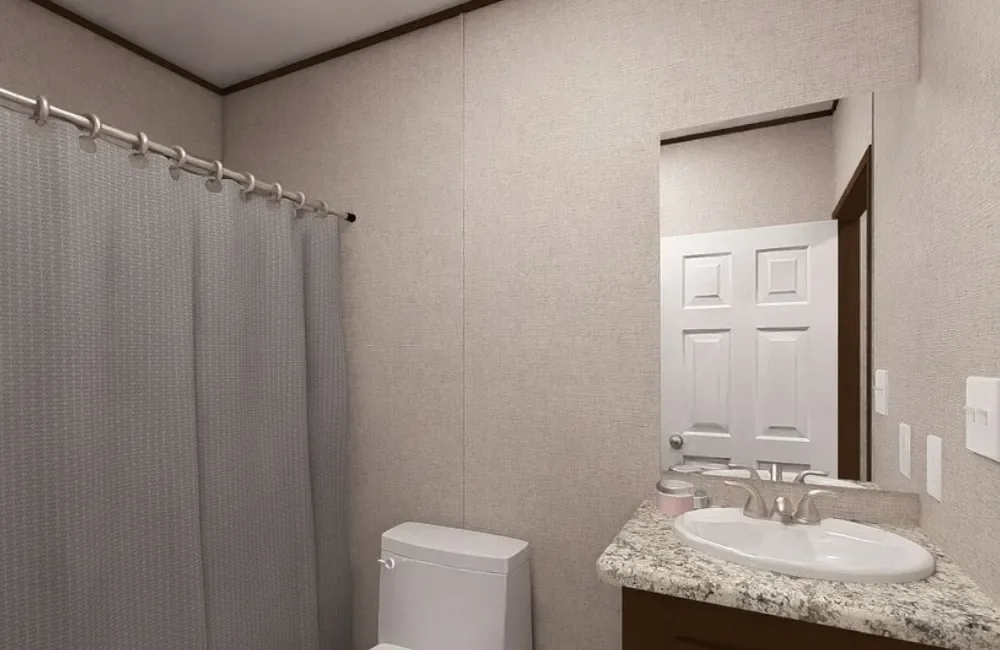 Bathroom with a shower, a toilet, a granite countertop with a sink, and a mirror, door in the background.