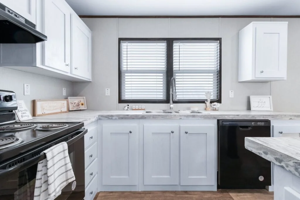 Kitchen with white cabinets, marble countertops, a black stove, black dishwasher, and a window with blinds.