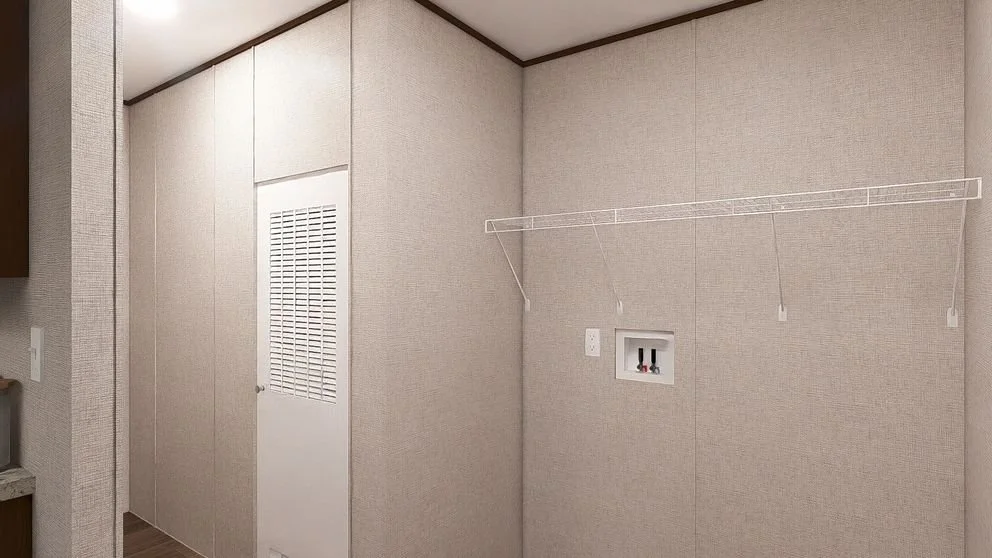 Empty laundry room with beige walls, a white wire shelf, a hook, and a small recessed area with water hookups.