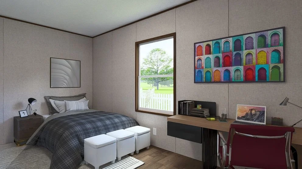 A bedroom with a bed, nightstand, desk with laptop, colorful wall art, and a window showing a tree outside.