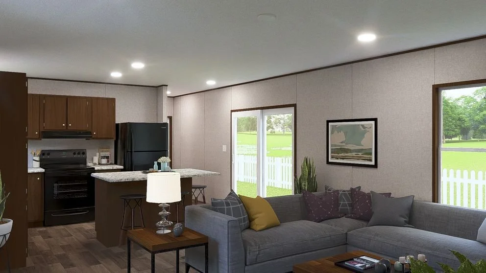 Living room with gray sectional sofa and gray walls, kitchen with dark cabinets and black appliances, sliding glass door, window, and indoor plants.