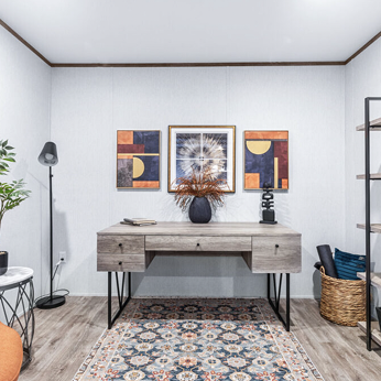 Modern living room with a wooden sideboard, abstract wall art, a tall black floor lamp, a potted plant, a woven basket, and a patterned rug.