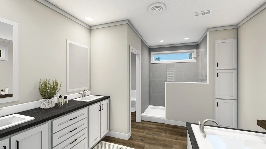 Modern bathroom with dual sinks, dark countertop, white cabinets, and a glass-enclosed shower with a high window.