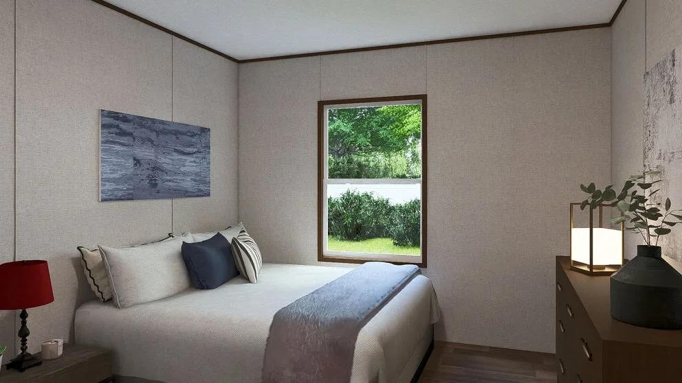 A bedroom with a bed, pillows, a window showing greenery outside, a nightstand with a red lamp, and a dresser with a vase, a lamp, and a leafy plant.