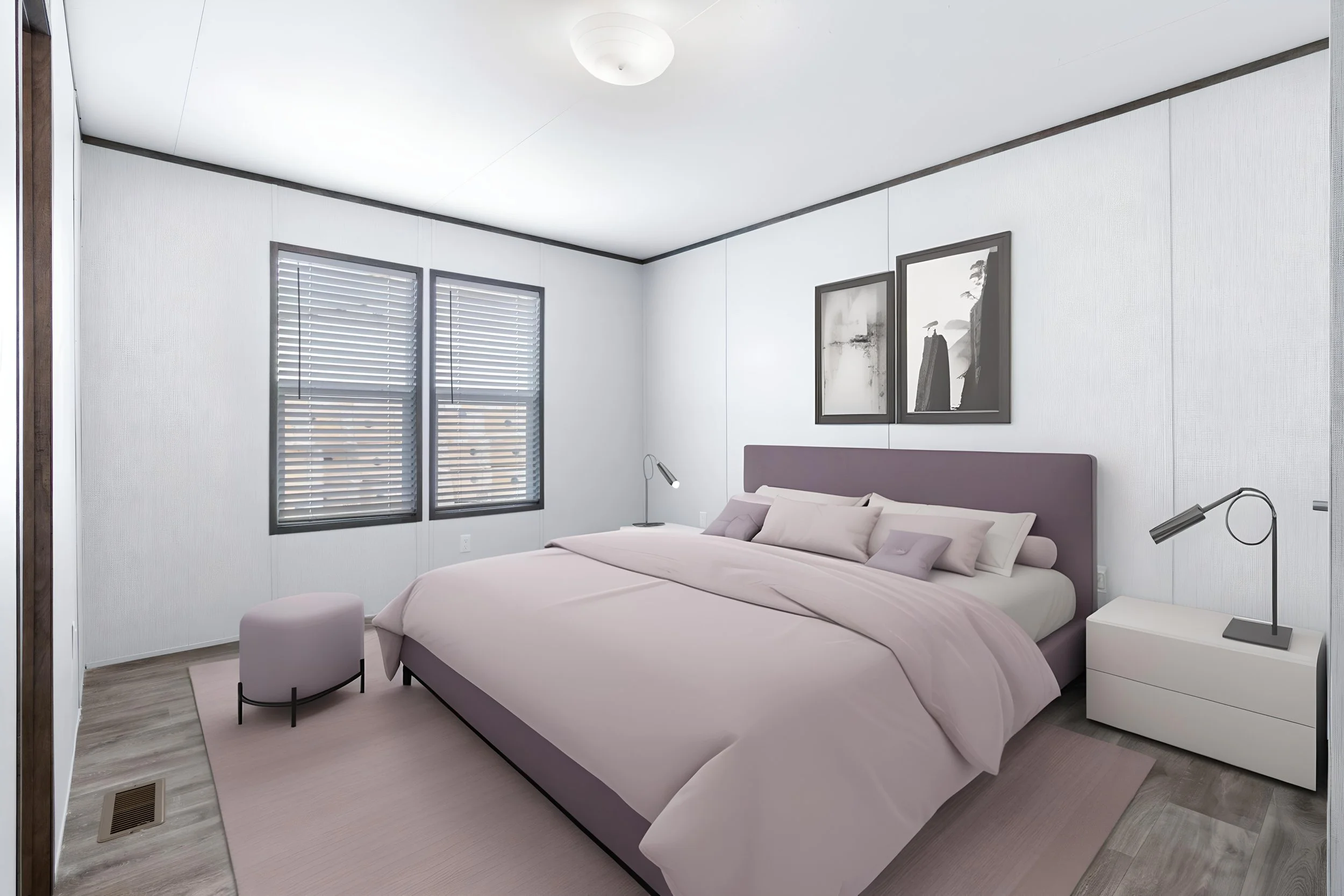 A bedroom with a bed, side table, and artwork on the wall. The room has white walls, gray trim, and two windows with blinds.
