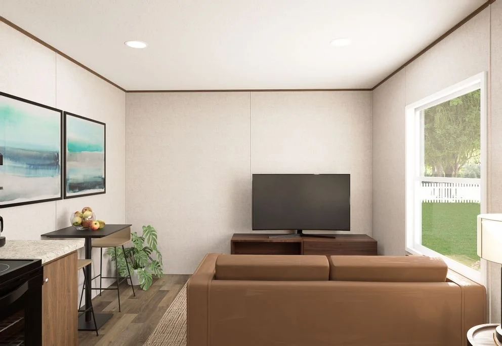 Living room with a brown leather sofa, a flat-screen TV on a wooden stand, a window showing a green yard, artwork on the wall, and a small table with fruit and a plant.