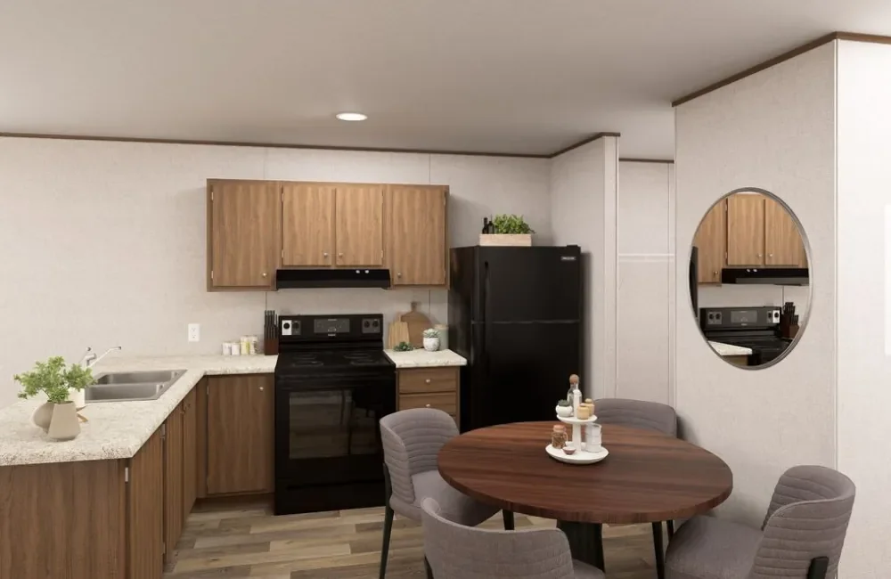 Kitchen with wooden cabinets, black stove and refrigerator, grey chairs around a round wooden table, decorative items on the table, mirror on the wall.