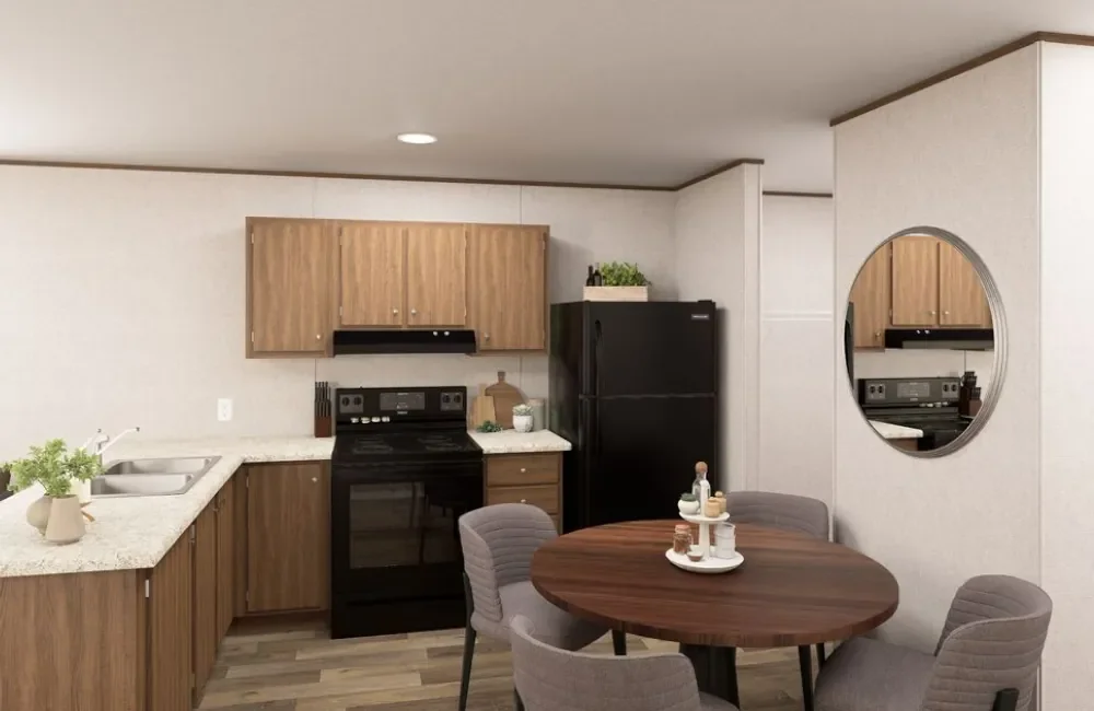 Kitchen with wooden cabinets, black refrigerator, black stove, round dining table with four gray chairs, and circular mirror on the wall.