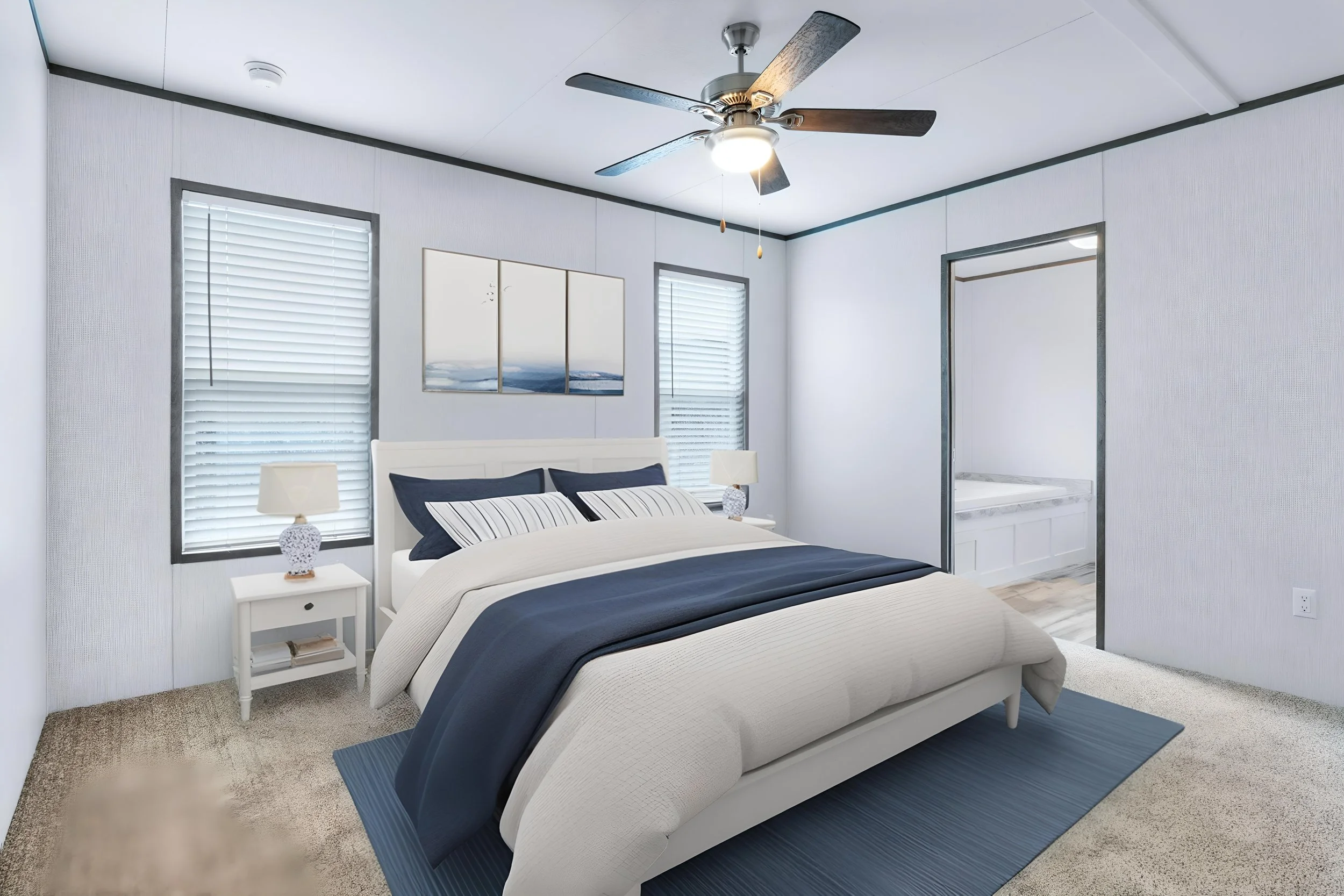 A bedroom with two beds, each with a white frame and striped bedding in shades of white and navy blue. There are two nightstands with lamps on either side of the beds and framed artwork above the headboard. The room has white walls, gray trim, two wi