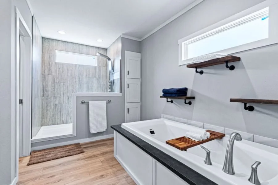 Modern bathroom with bathtub, walk-in shower, and wood shelves with towels
