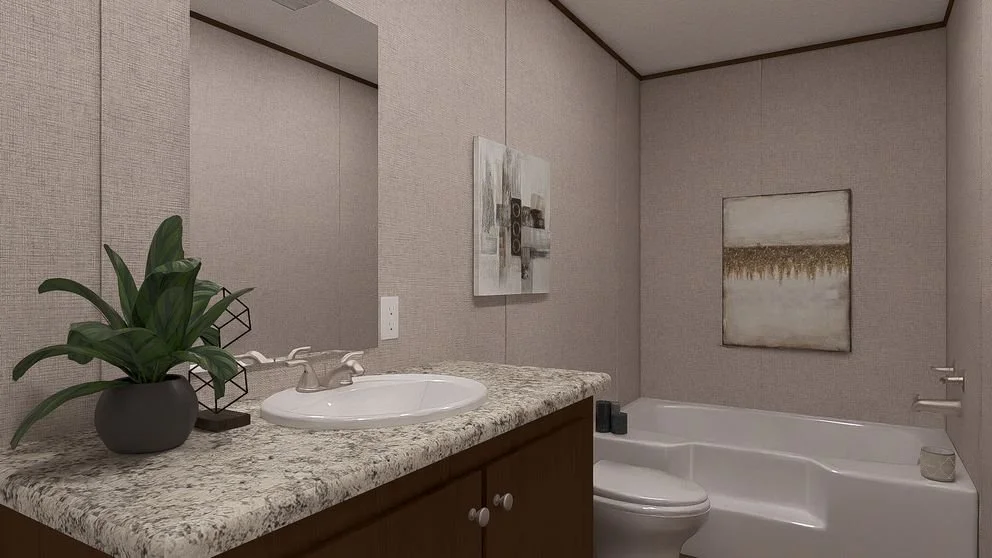 A bathroom with a granite countertop, a sink, a potted plant, artwork on the wall, a bathtub, a toilet, and a mirror.