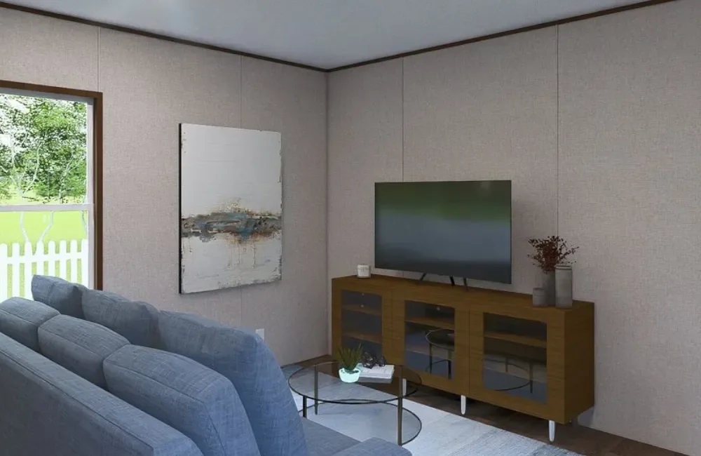 Living room with light-colored walls, gray couch, coffee table with small plant, wall art, flat-screen TV on wooden console, and window showing green outdoor scenery.
