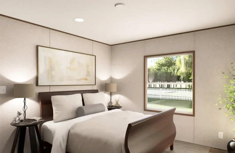 A cozy bedroom with a wooden bed, white bedding, two matching lamps on side tables, a window showing a green backyard, and light-colored walls.