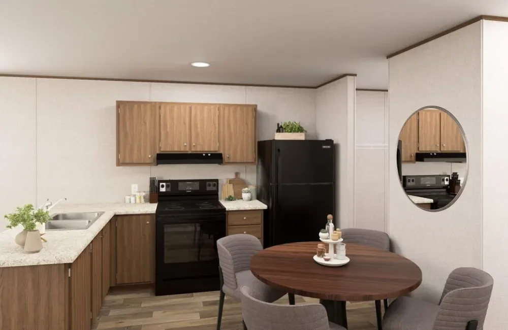Kitchen with wooden cabinets, black stove and refrigerator, white countertops, round dining table with four gray chairs, and a mirror on the wall.