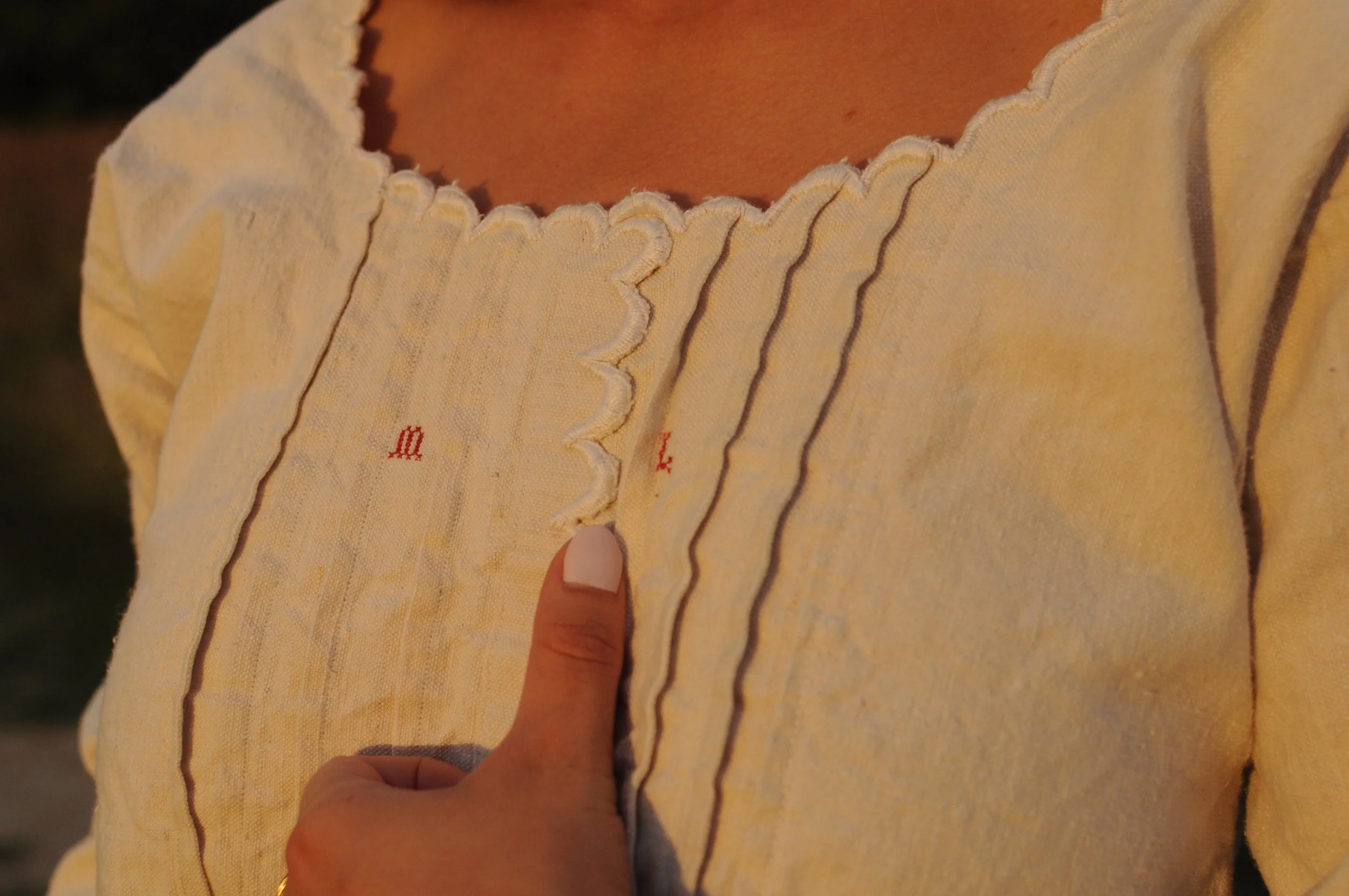 Close-up of scalloped neckline and hand-stitched pintucks on antique French linen dress