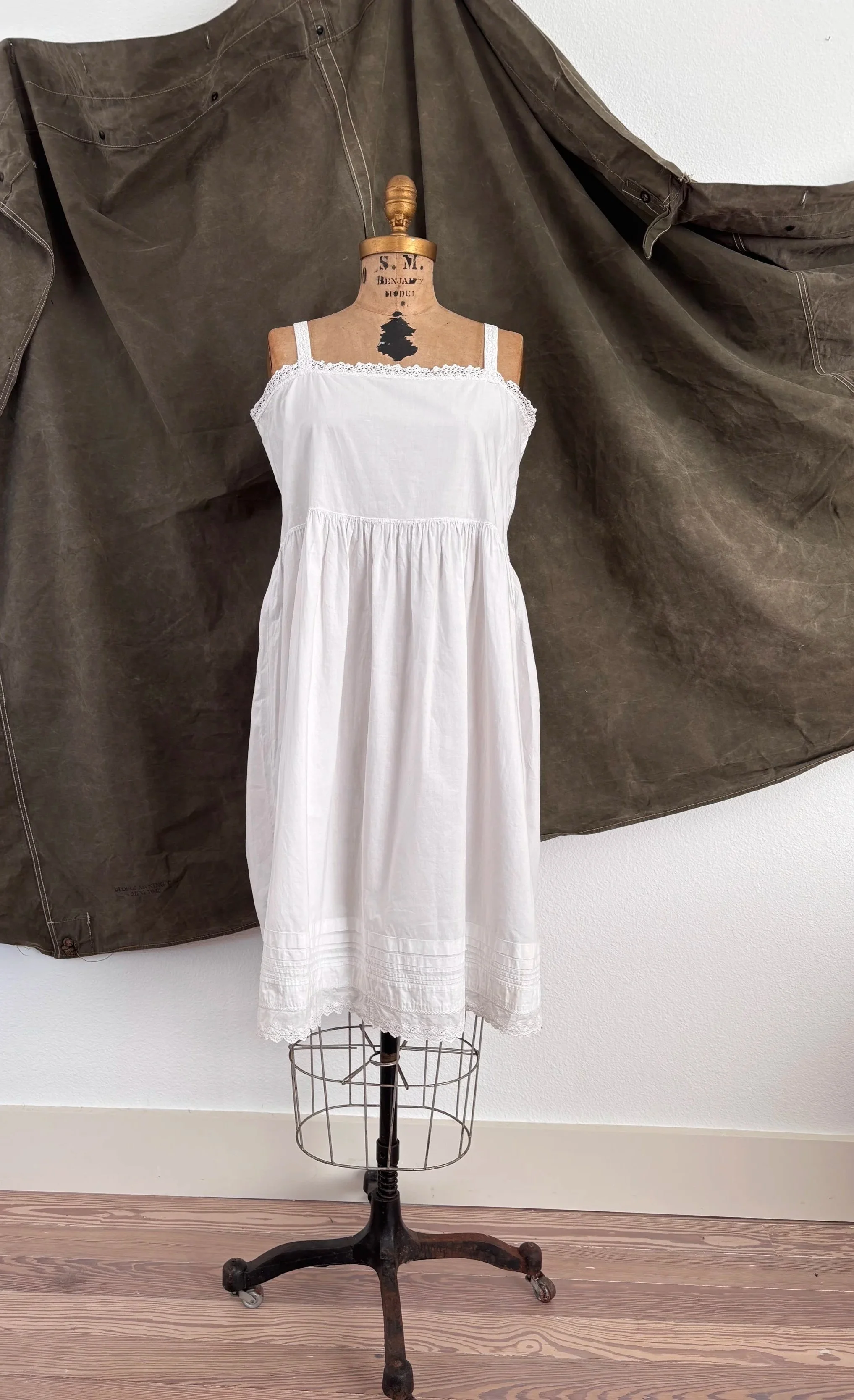 Front view of antique heirloom cotton empire waist slip dress on dress form