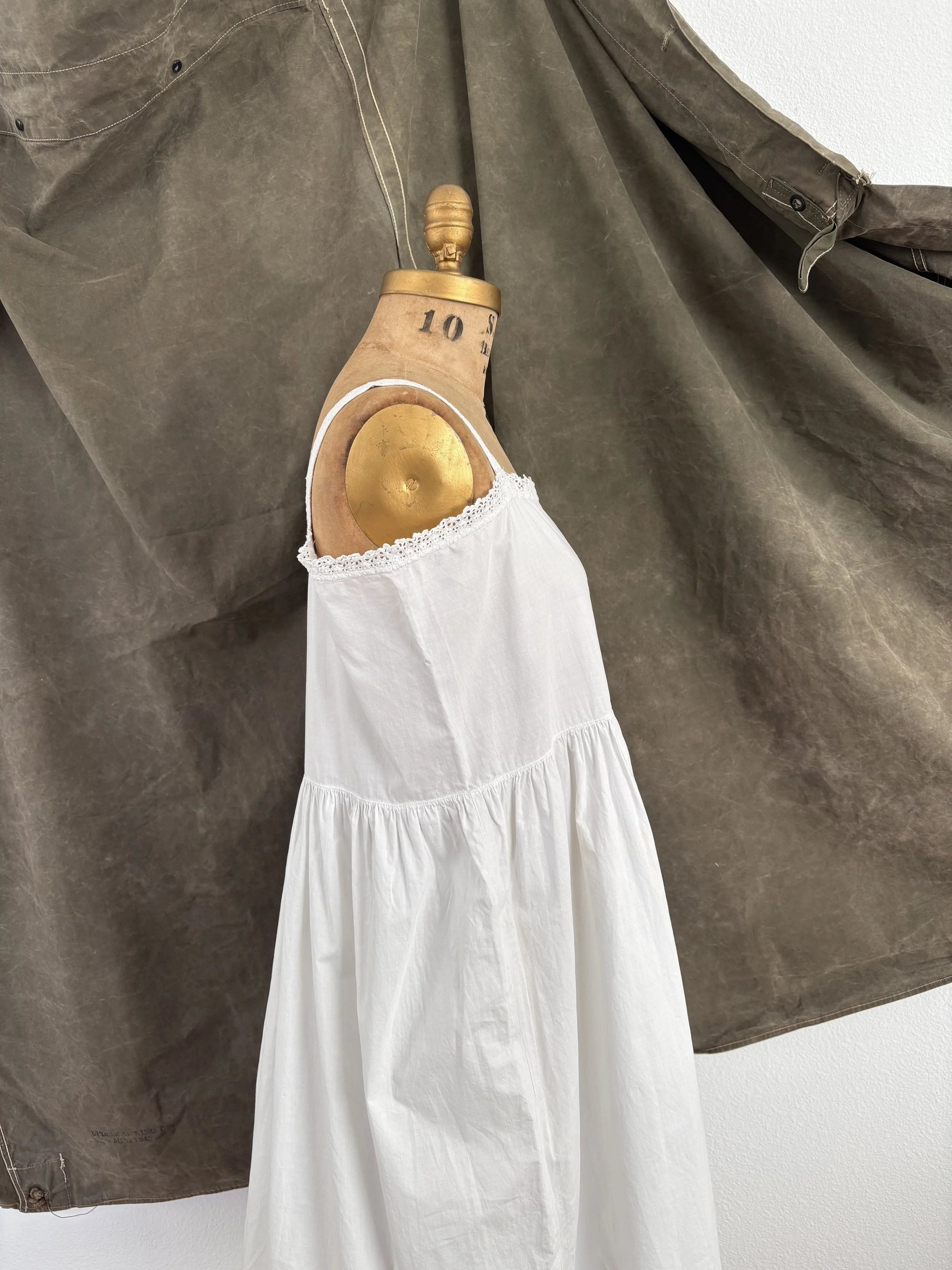 Side view of antique 1920s cotton empire waist slip dress on dress form