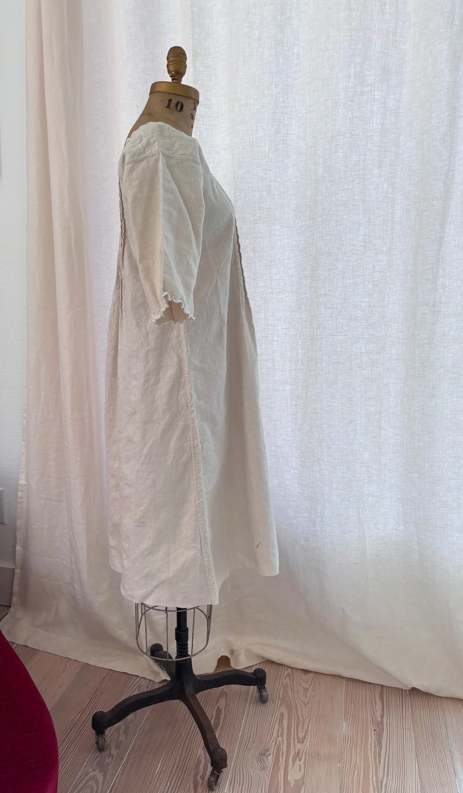 Side view of antique French homespun linen day dress showing drape and silhouette