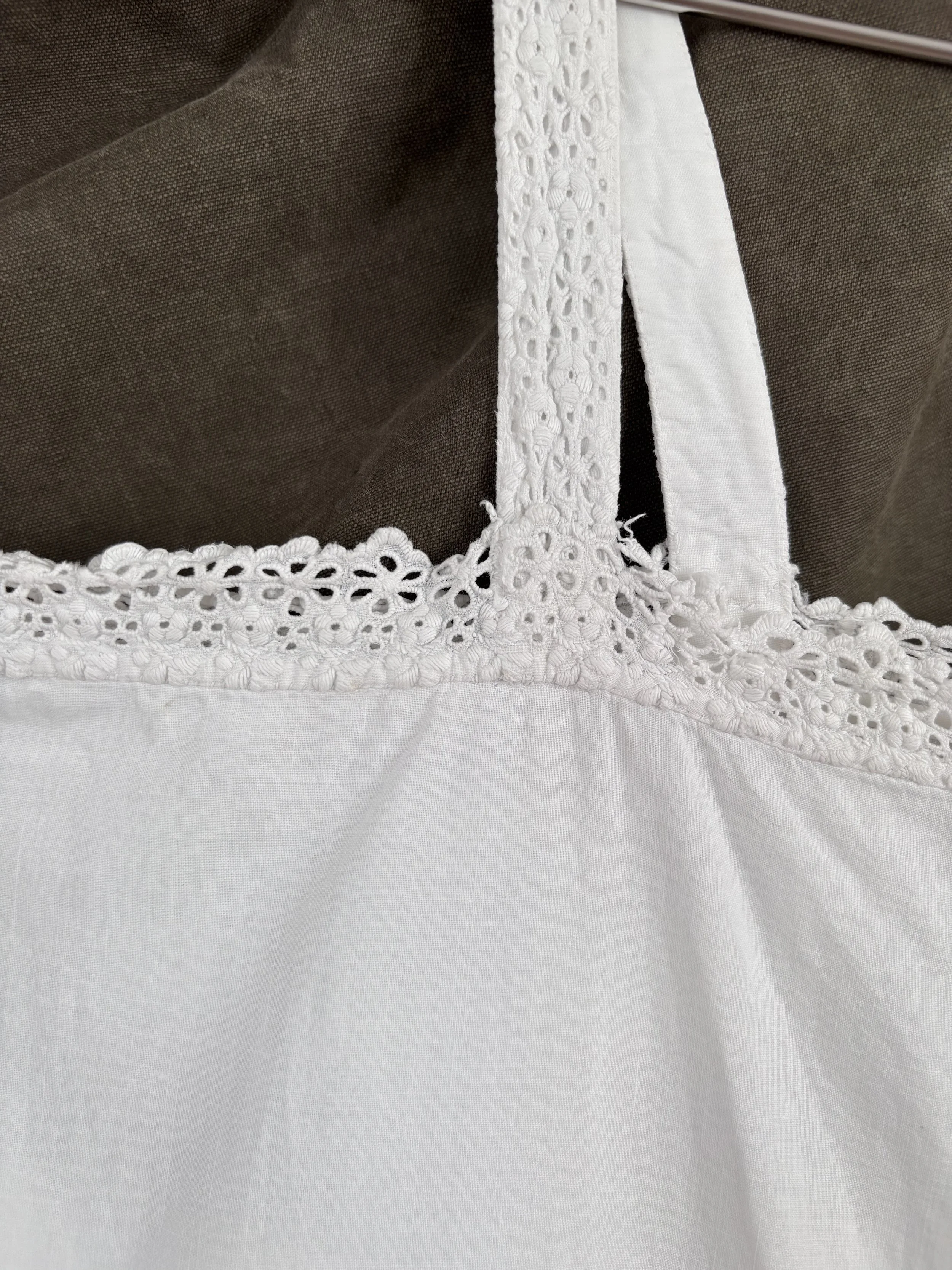 Close-up of lace shoulder strap and neckline on antique heirloom cotton slip dress