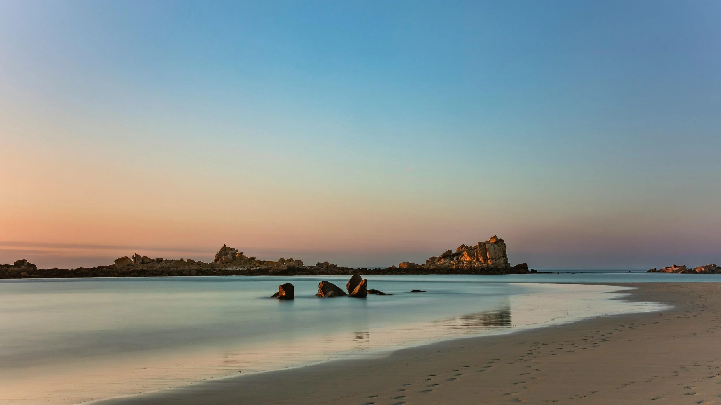 Plage au coucher de soleil à Saint-Briac-sur-Mer en Bretagne, lieu idéal pour retraite yoga, méditation et séjour bien-être en bord de mer.